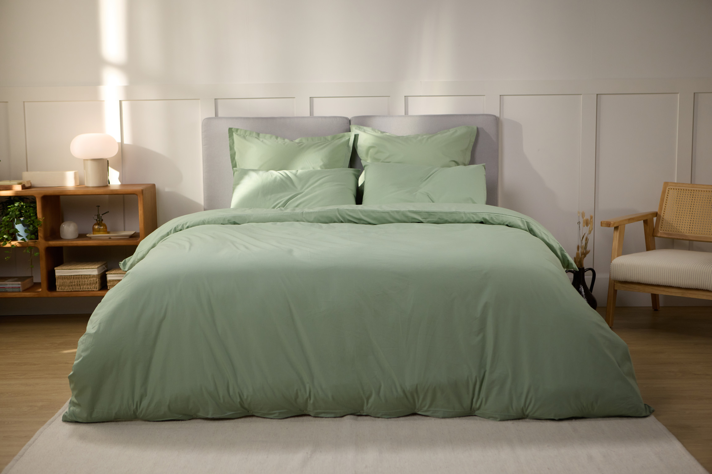 Vue de face d’une chambre décorée, avec un lit doté d’une couette colorée et de taies d’oreiller.