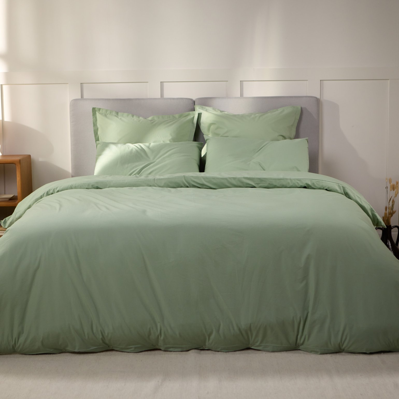 Vue de face d’une chambre décorée, avec un lit doté d’une couette colorée et de taies d’oreiller.