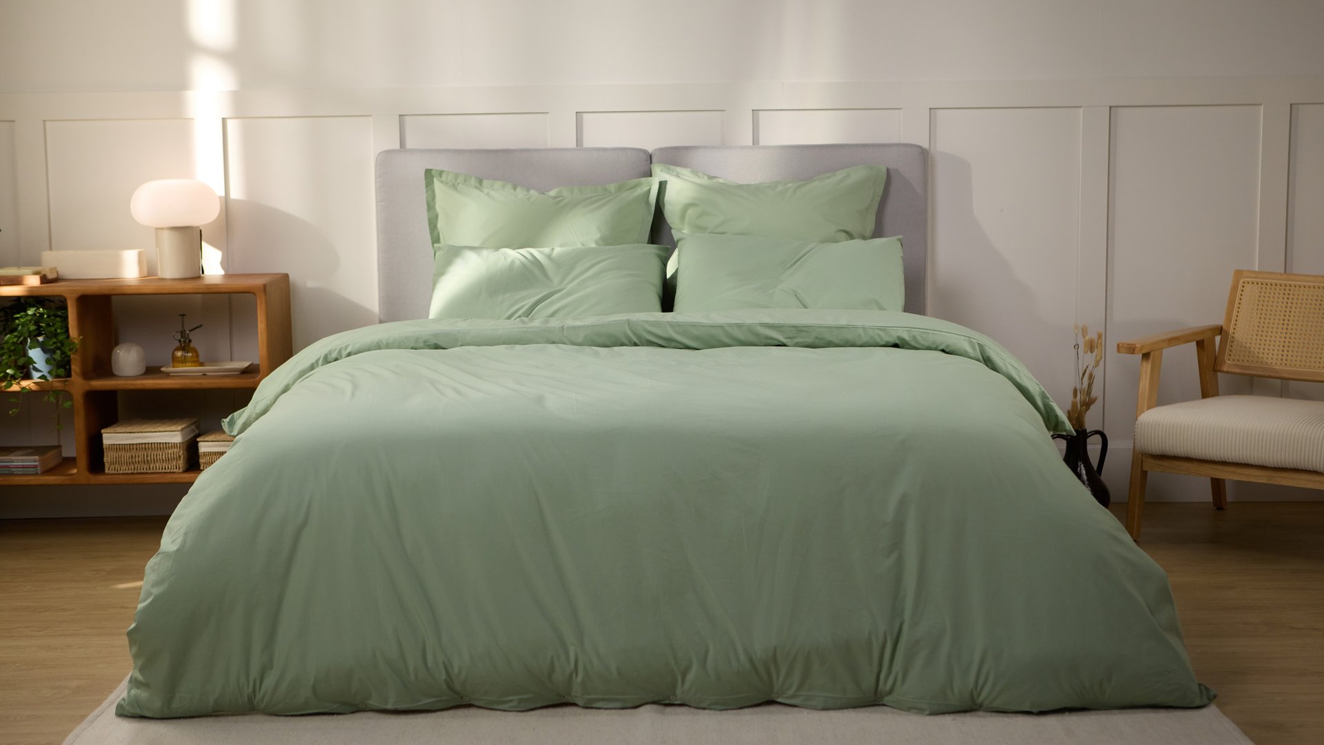 Vue de face d’une chambre décorée, avec un lit doté d’une couette colorée et de taies d’oreiller.