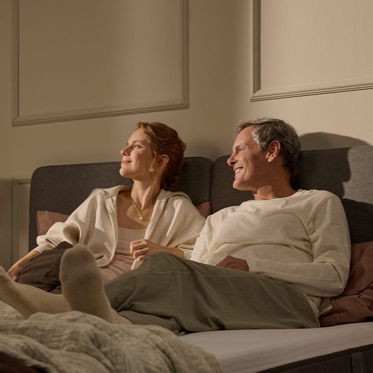 A bundle with mattress, pillows, mattress protector and a duvet on a white and orange background.