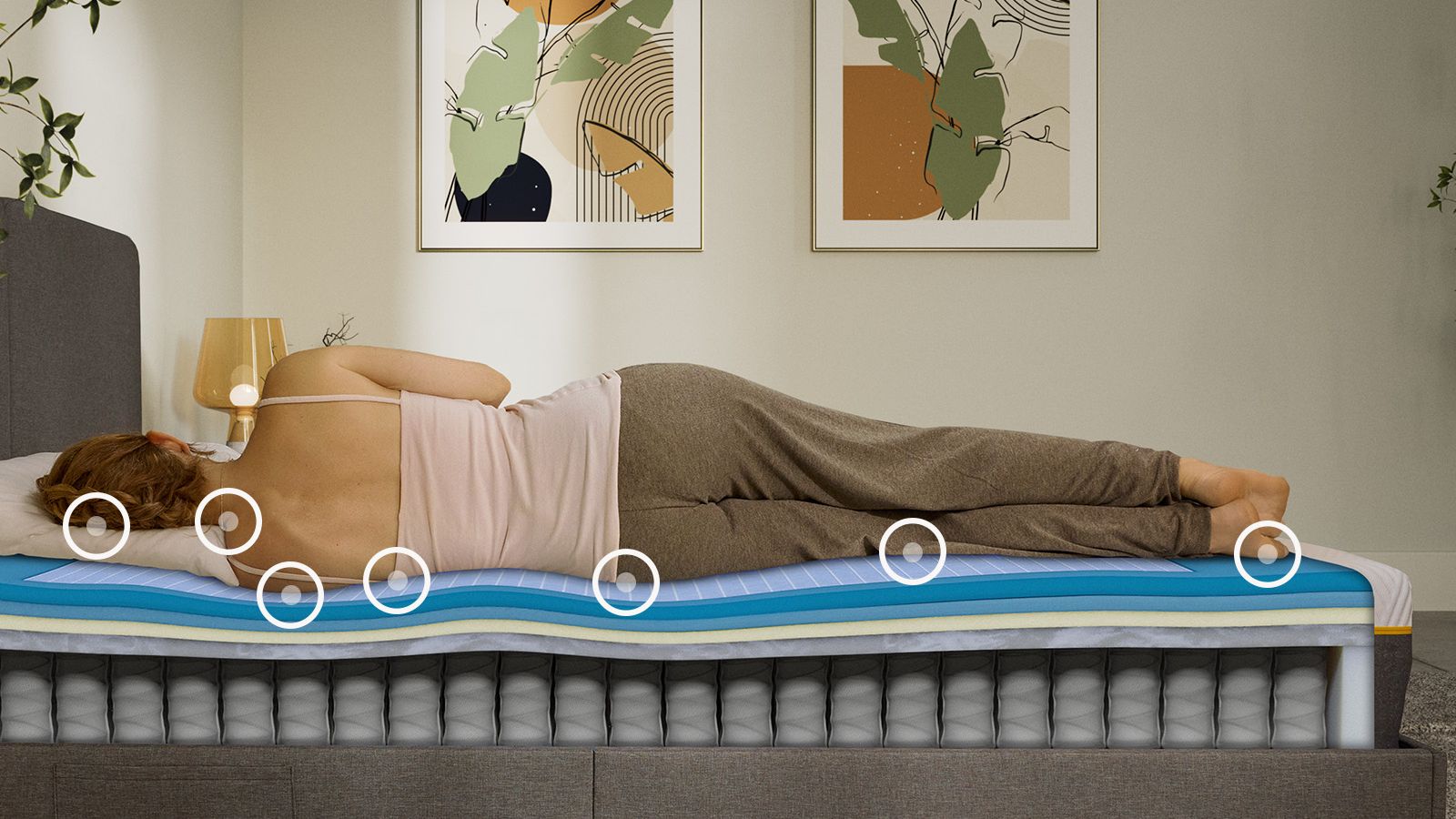 Mulher a dormir de lado num colchão Emma Original Elite, com uma vista em camadas que mostra a construção de espuma e molas por baixo dela.