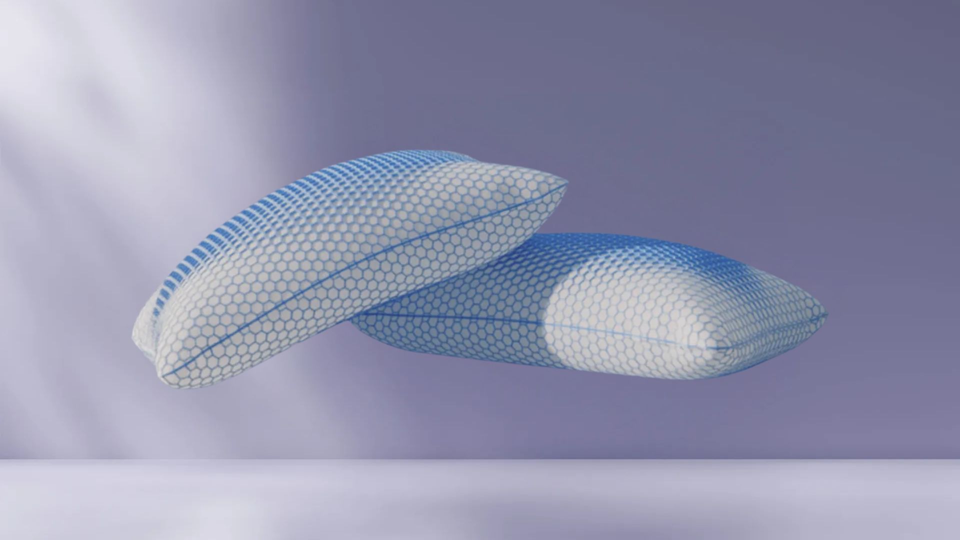 Twee AirGrid® Comfort Kussens met witte hoes en blauwe honingraatpatroon, zwevend tegen een zachte paarse achtergrond.