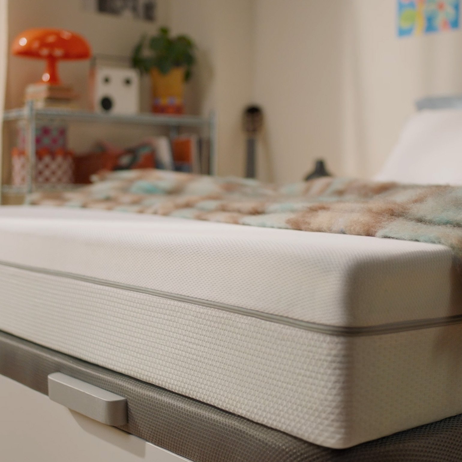 White mattress shown in a bedroom setting.