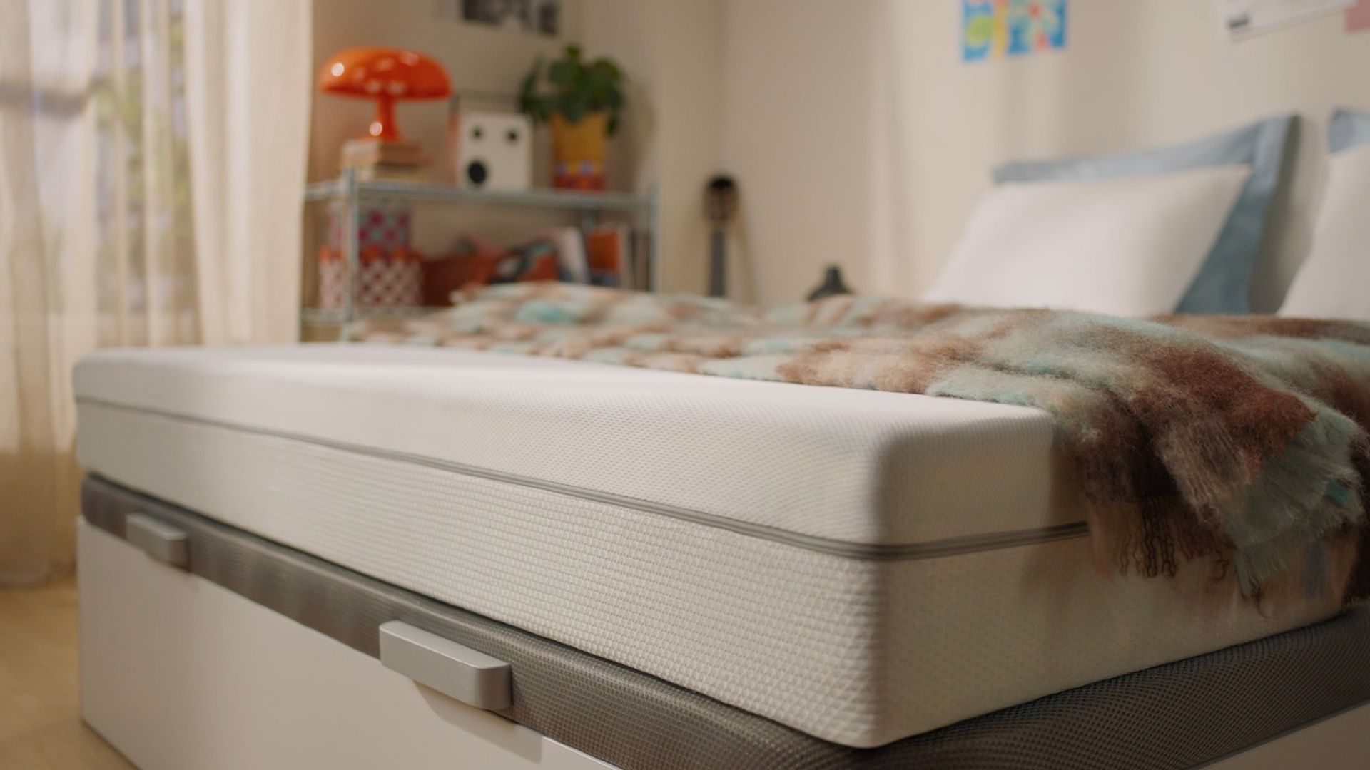 White mattress shown in a bedroom setting.