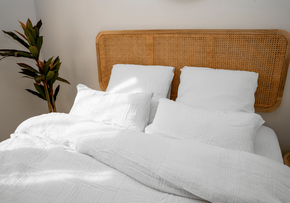 Lit avec couette et taies d’oreiller sur un cadre en bois.