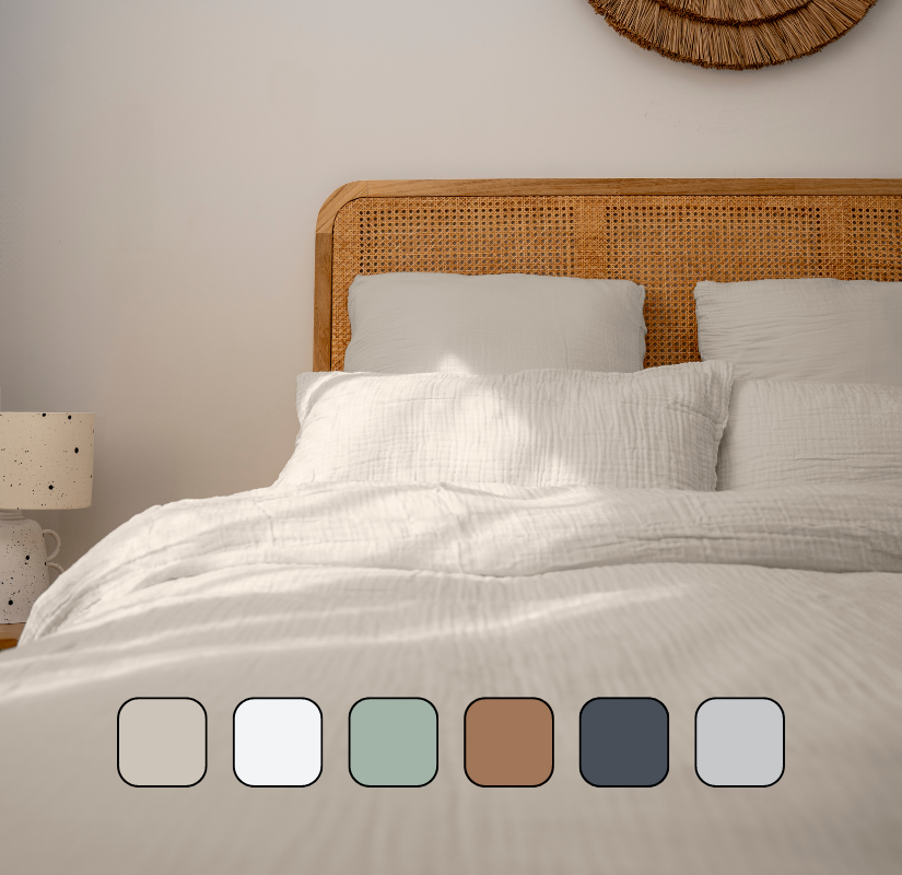 Image en gros plan d’un lit avec des oreillers et une housse de couette.