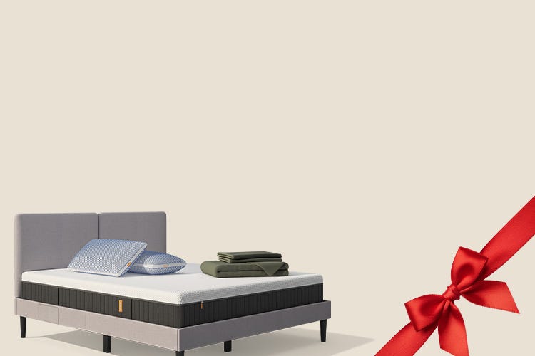 Lit moderne avec tête de lit grise et pieds noirs, recouvert de draps blancs. Deux oreillers blancs et une pile de linge plié sont posés sur le matelas. Arrière-plan beige avec une forme orange abstraite.