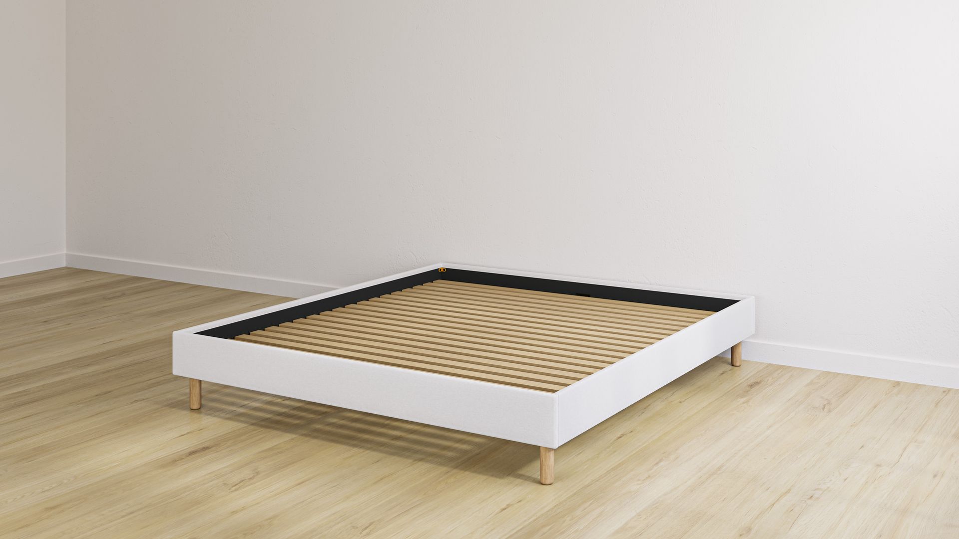 Beige bedframe met houten lattenbodem in een lege kamer met lichte houten vloer.