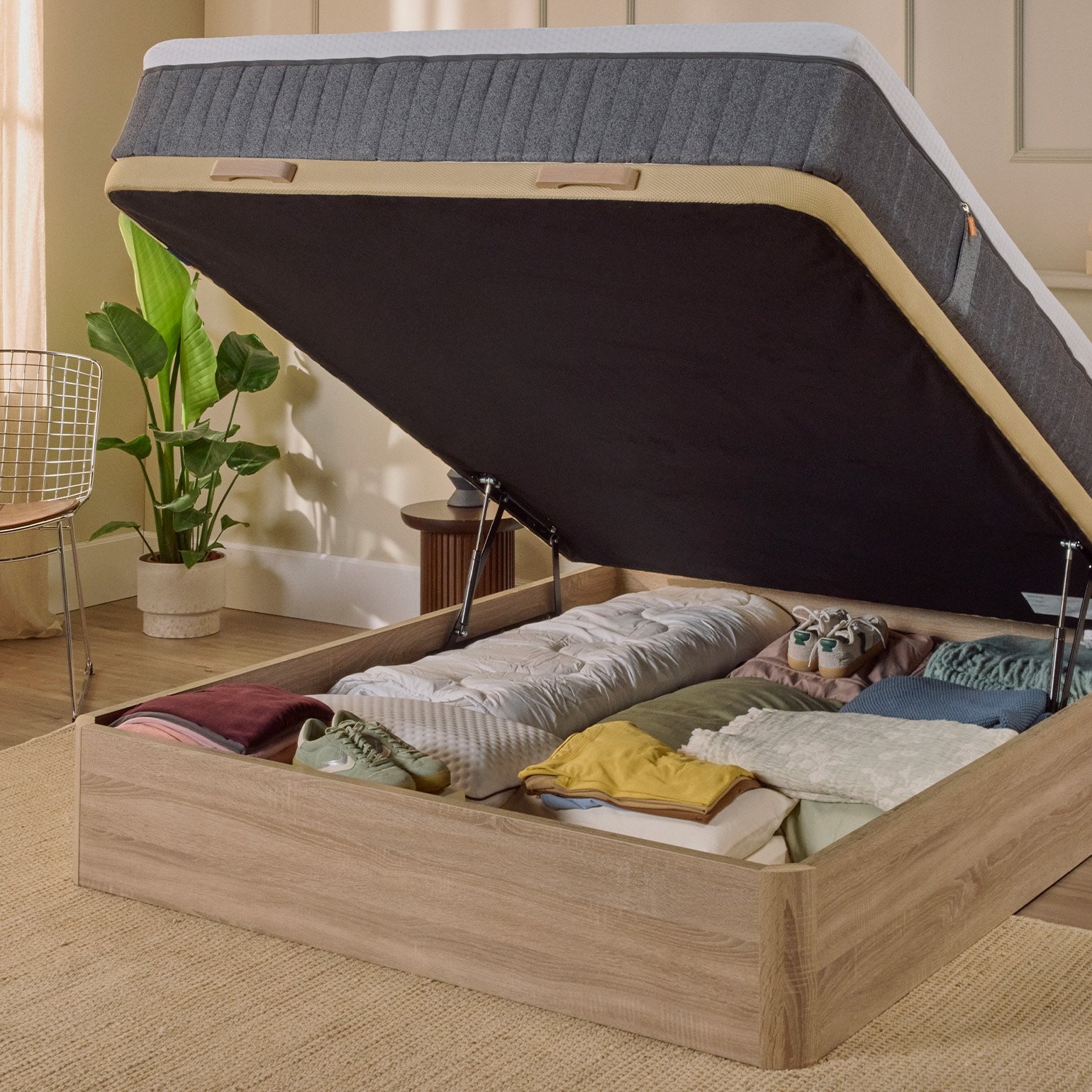 Imagem de um sommier com arumação Emma, com um acabamento castanho, com a base levantada, a mostrar o espaço de arrumação da cama.