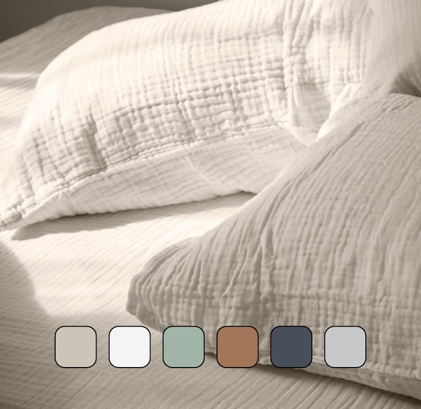 Image en gros plan d’oreillers posés sur un lit.