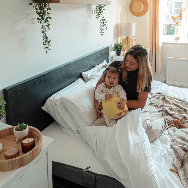 Woman and child sitting on a Emma mattress.