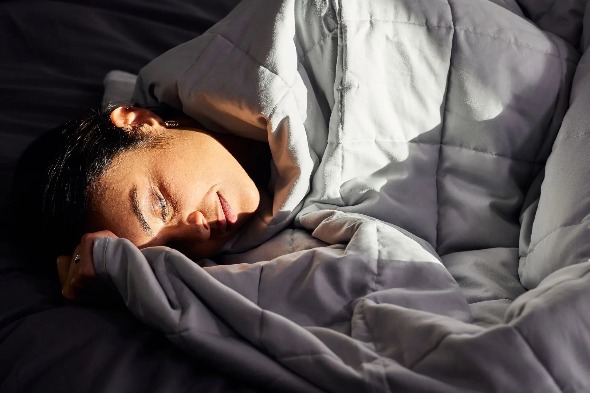 Personne allongée, couverte d’une couette.
