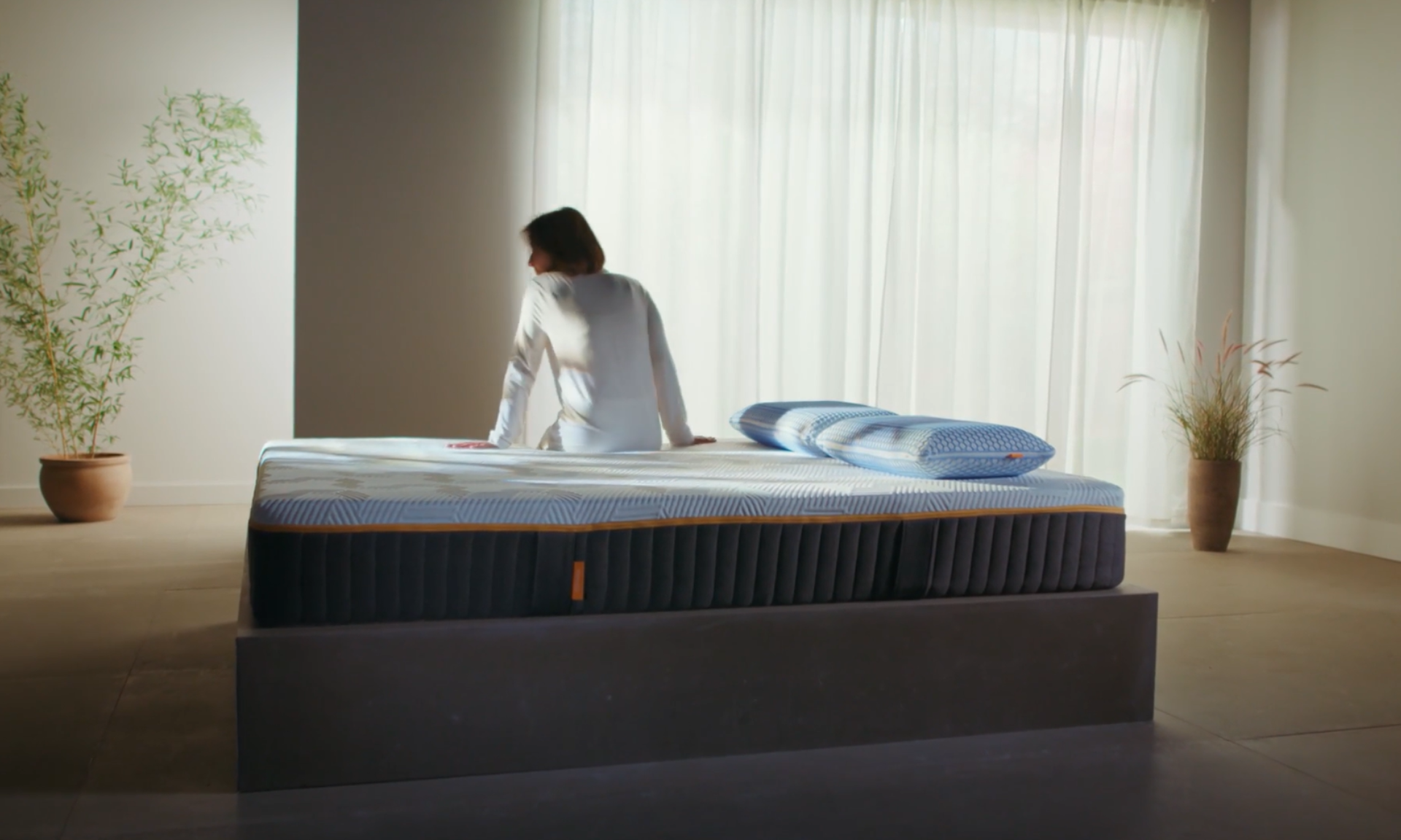 mujer sentada en colchon emma hybrid elite