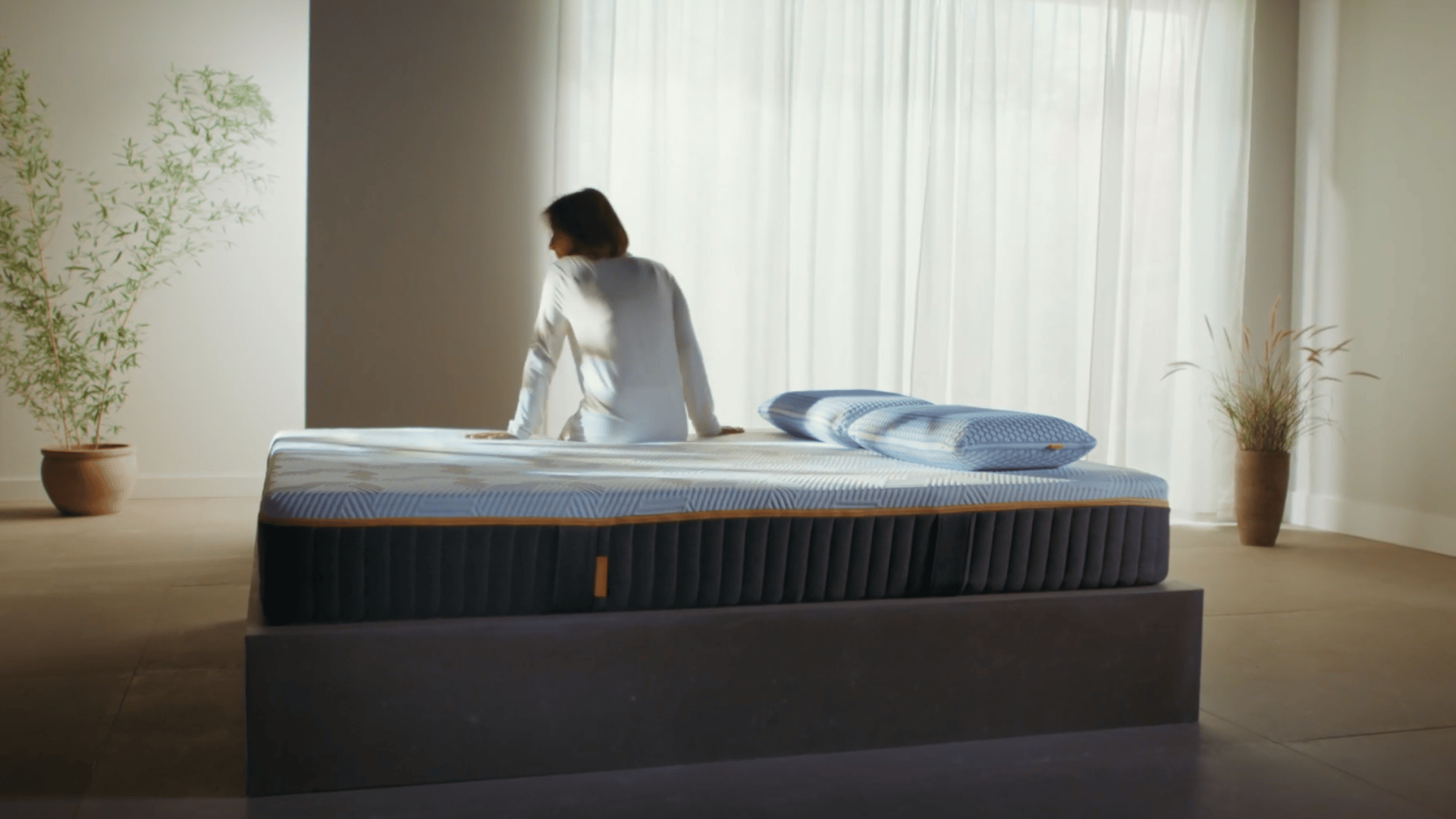 mujer sentada en colchon emma hybrid elite