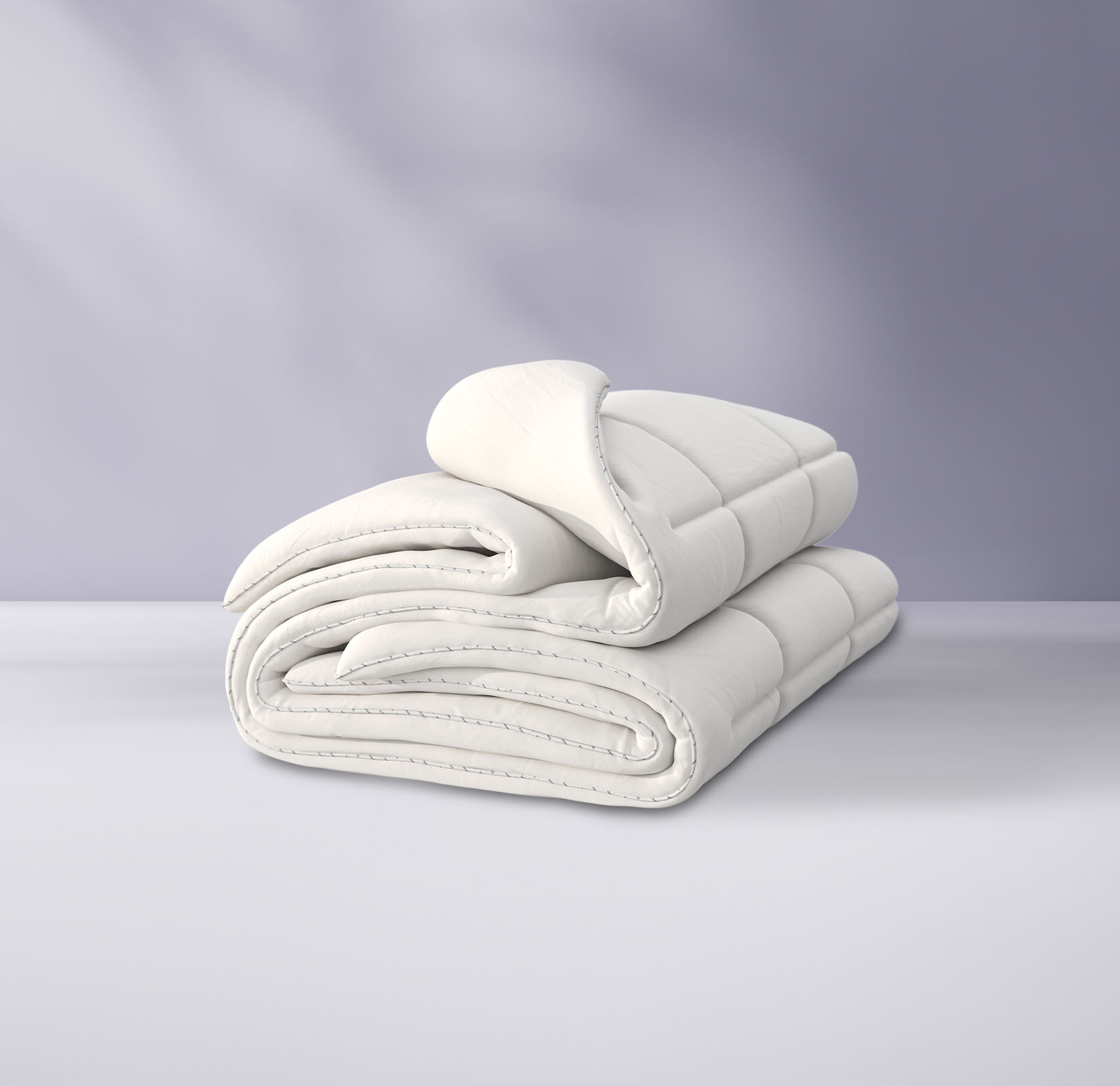 Couette pliée sur un fond violet clair.