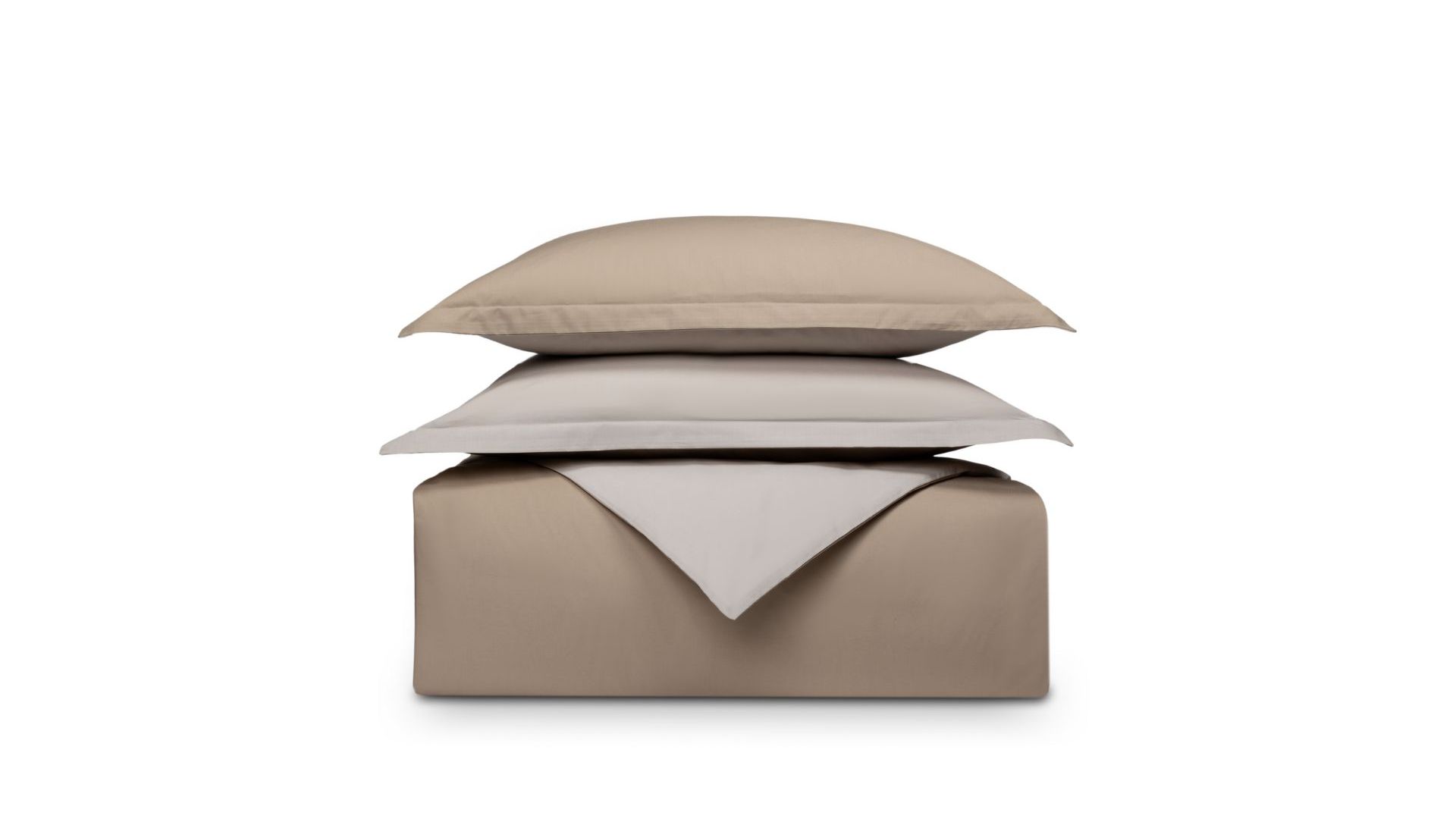 Set di biancheria piegato beige e sabbia su sfondo bianco, cuscino sopra il piumone.