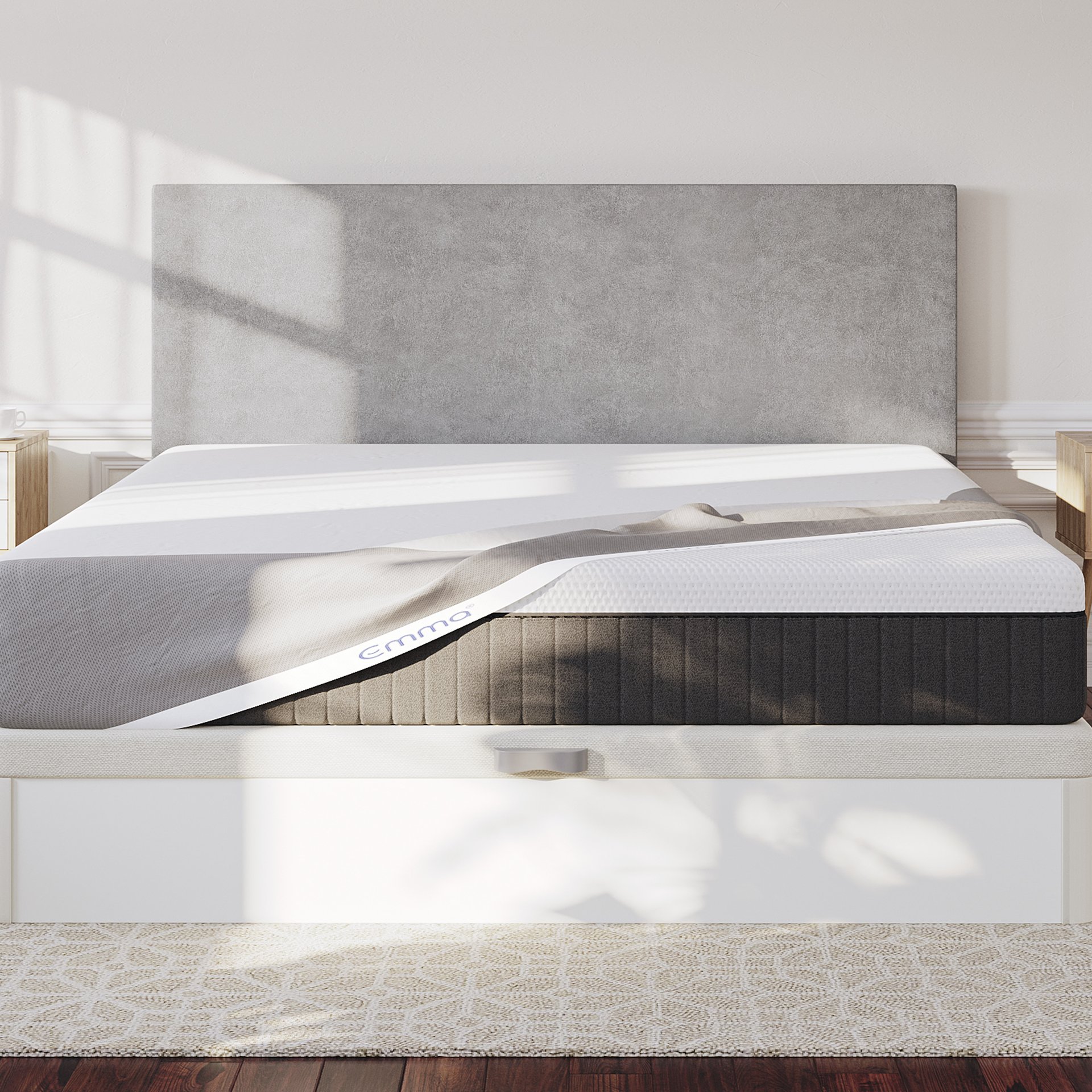  Emma bed and and Emma Mattress Protector. The bed has a grey upholstered headboard, and natural light casting shadows across the mattress.