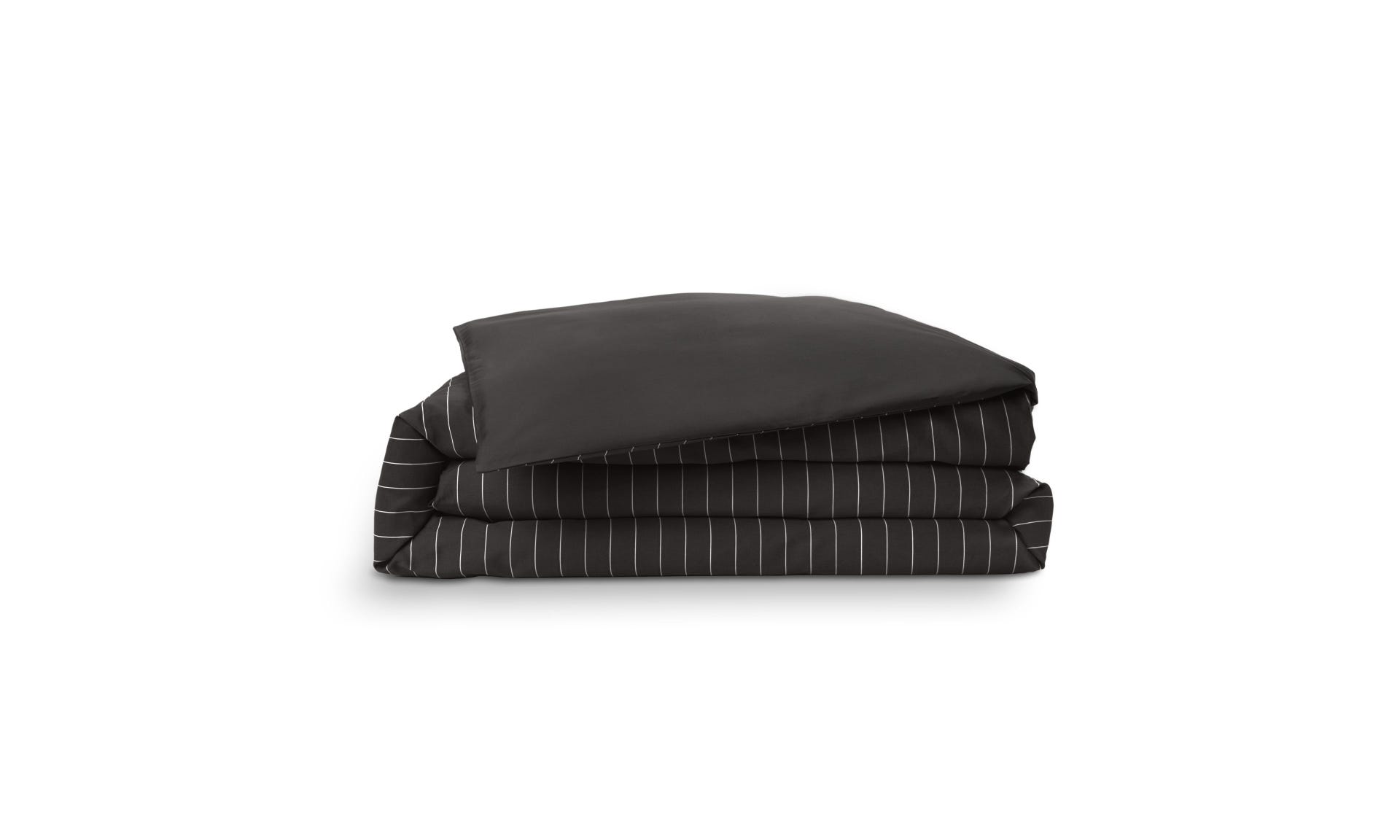 Copripiumino piegato con motivo a righe bianche su base grigio scuro