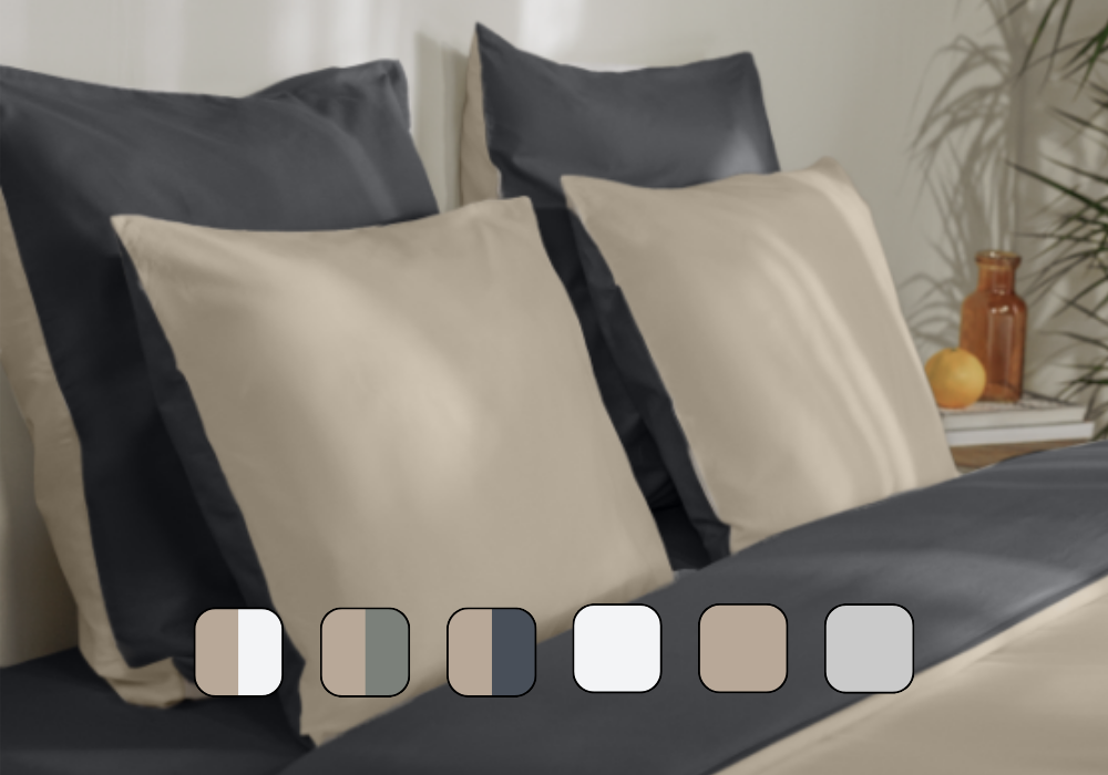 Image en gros plan d’un lit avec des oreillers et une housse de couette.