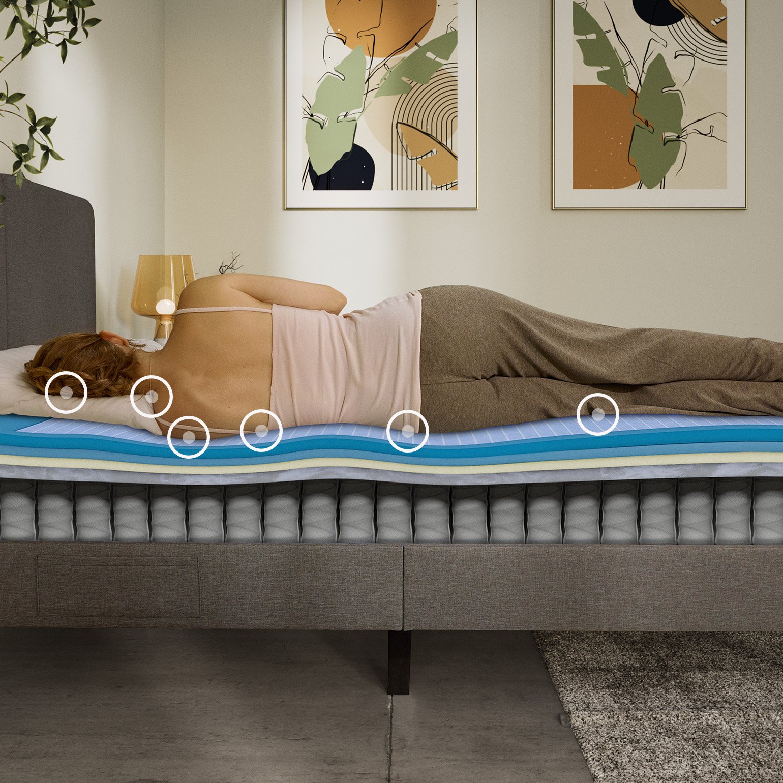 Woman sleeping on her side on an Emma Original Elite mattress with a layers view showing foam and spring construction beneath her.
