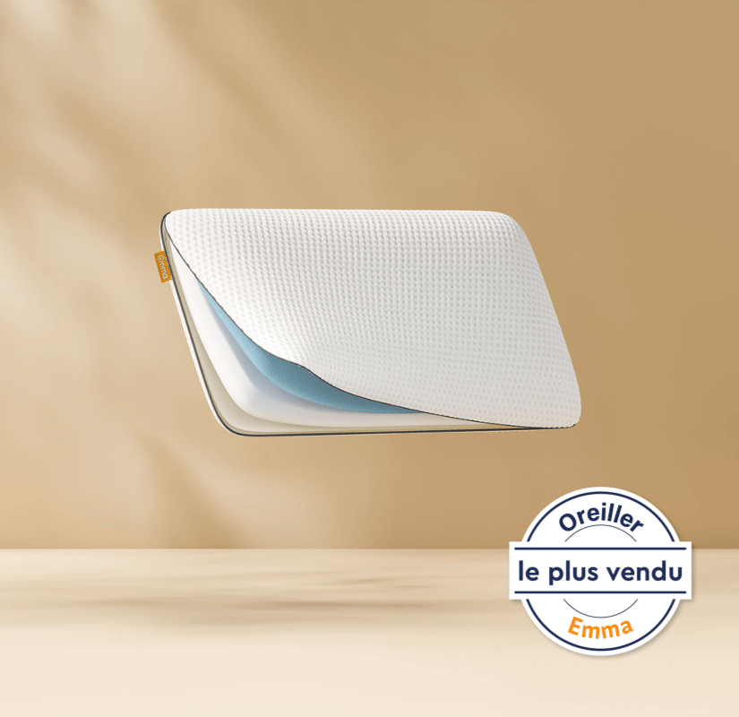 Oreiller flottant montrant ses couches de mousse internes avec un logo Emma. Fond bronze clair.