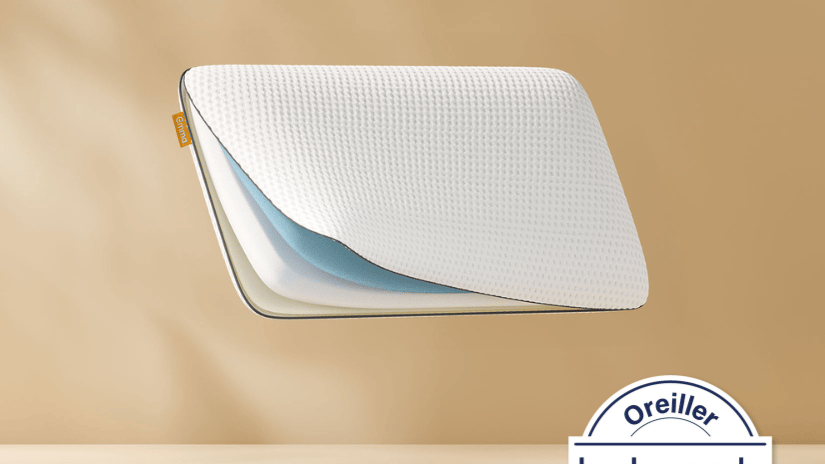 Oreiller flottant montrant ses couches de mousse internes avec un logo Emma. Fond bronze clair.