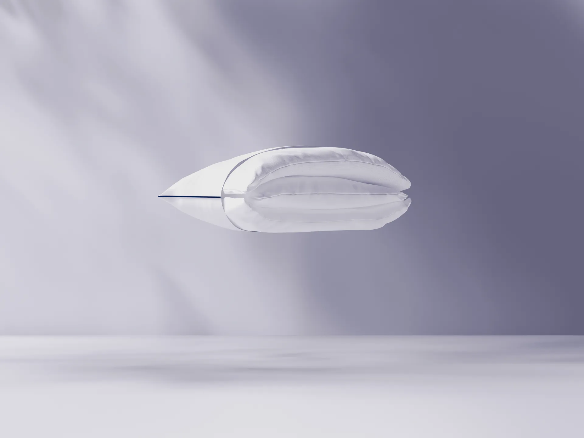 Cuscino bianco sospeso su sfondo viola chiaro