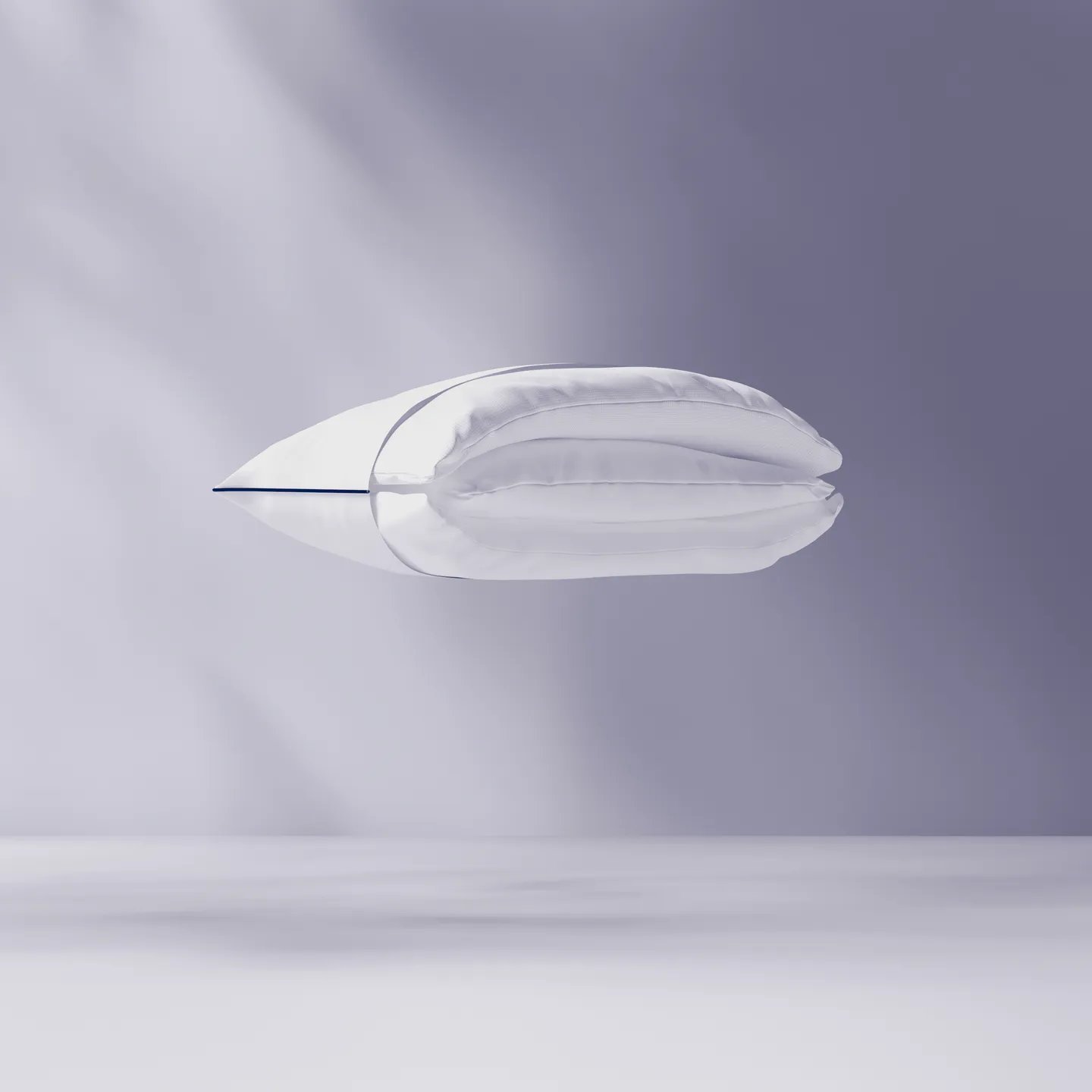 Cuscino bianco sospeso su sfondo viola chiaro
