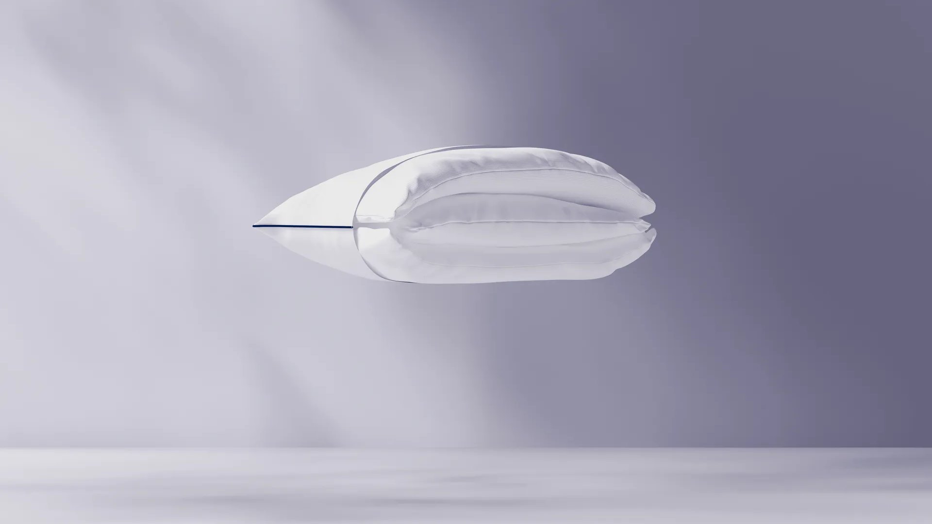 Cuscino bianco sospeso su sfondo viola chiaro