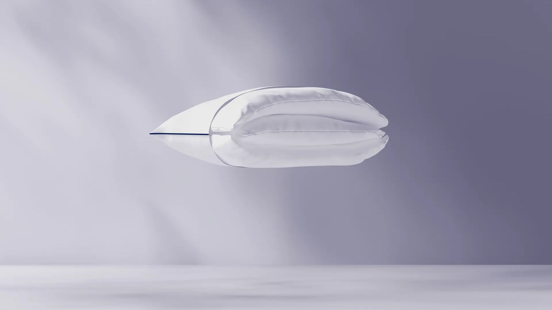 Cuscino bianco sospeso su sfondo viola chiaro