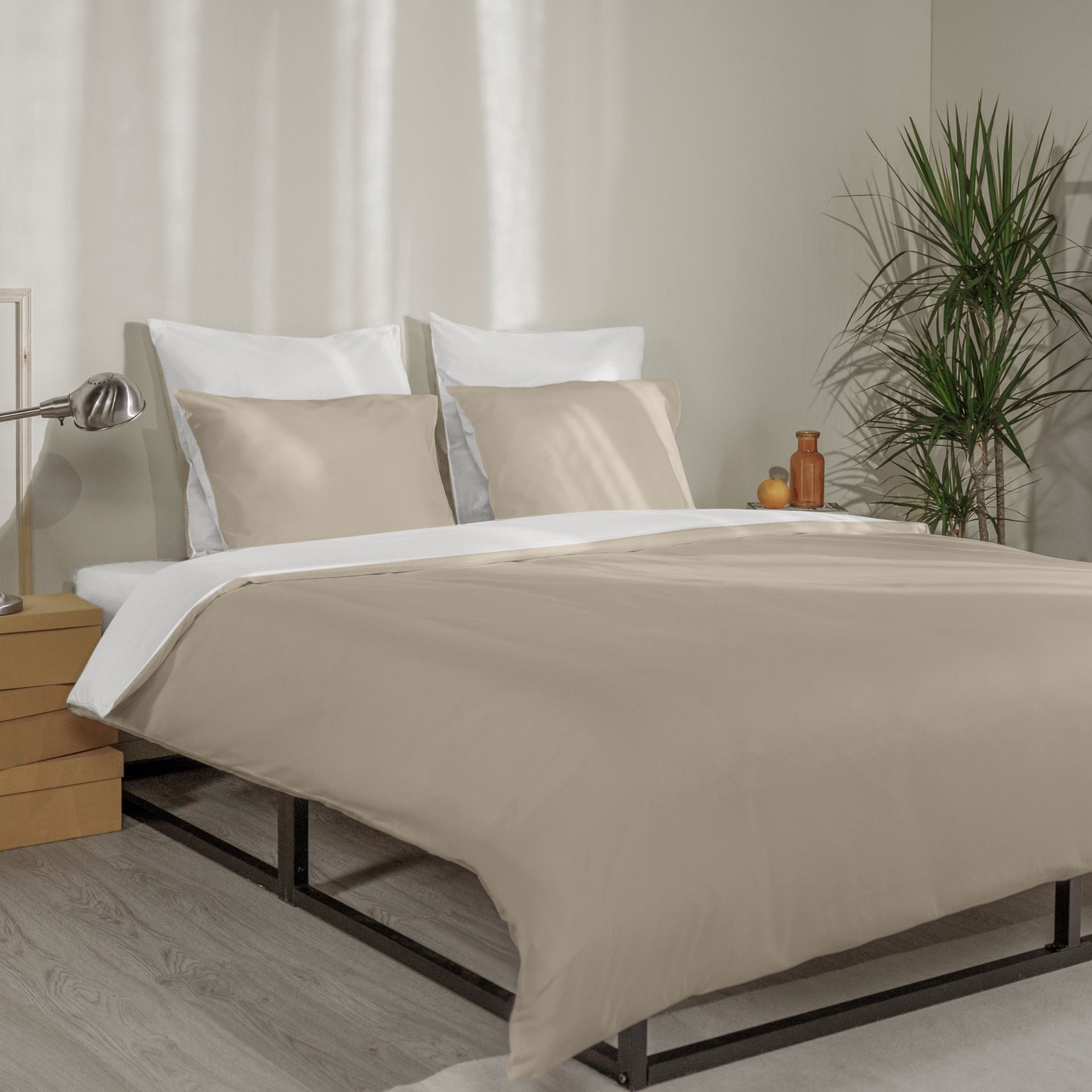 Letto con federe beige e bianche, copripiumino coordinato e testiera in legno a doghe.