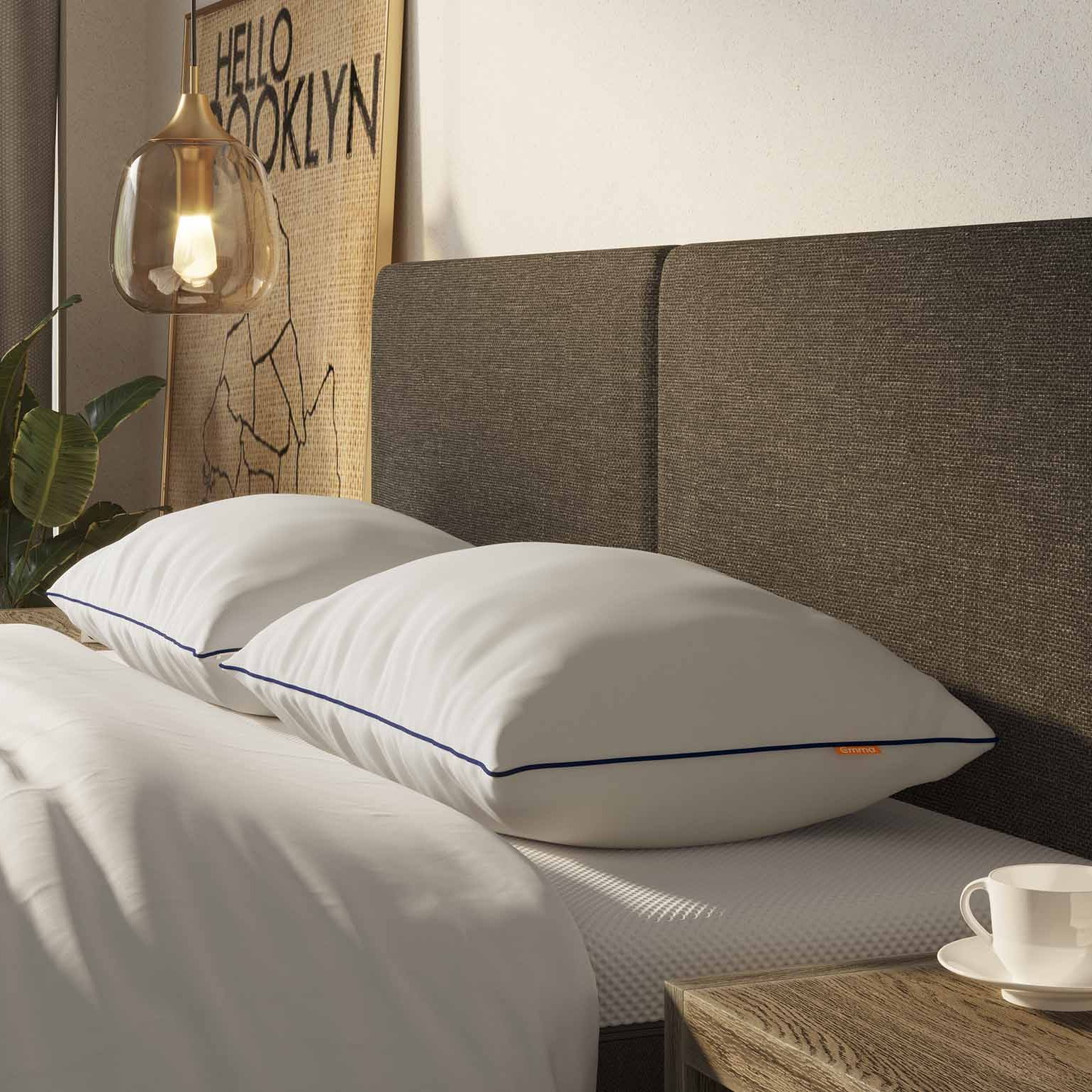 Letto con due cuscini bianchi, comodino a lato