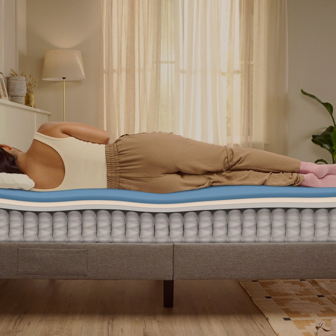 Person lying on their side on a white mattress in a relaxed sleeping position.