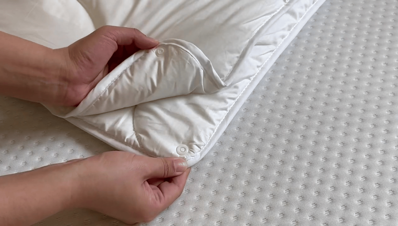 Mains montrant le mécanisme de fermeture de la couette.