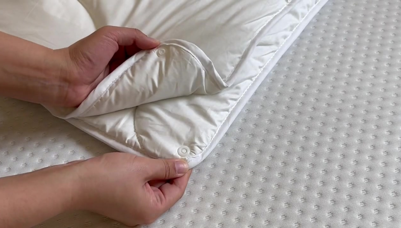 Mains montrant le mécanisme de fermeture de la couette.
