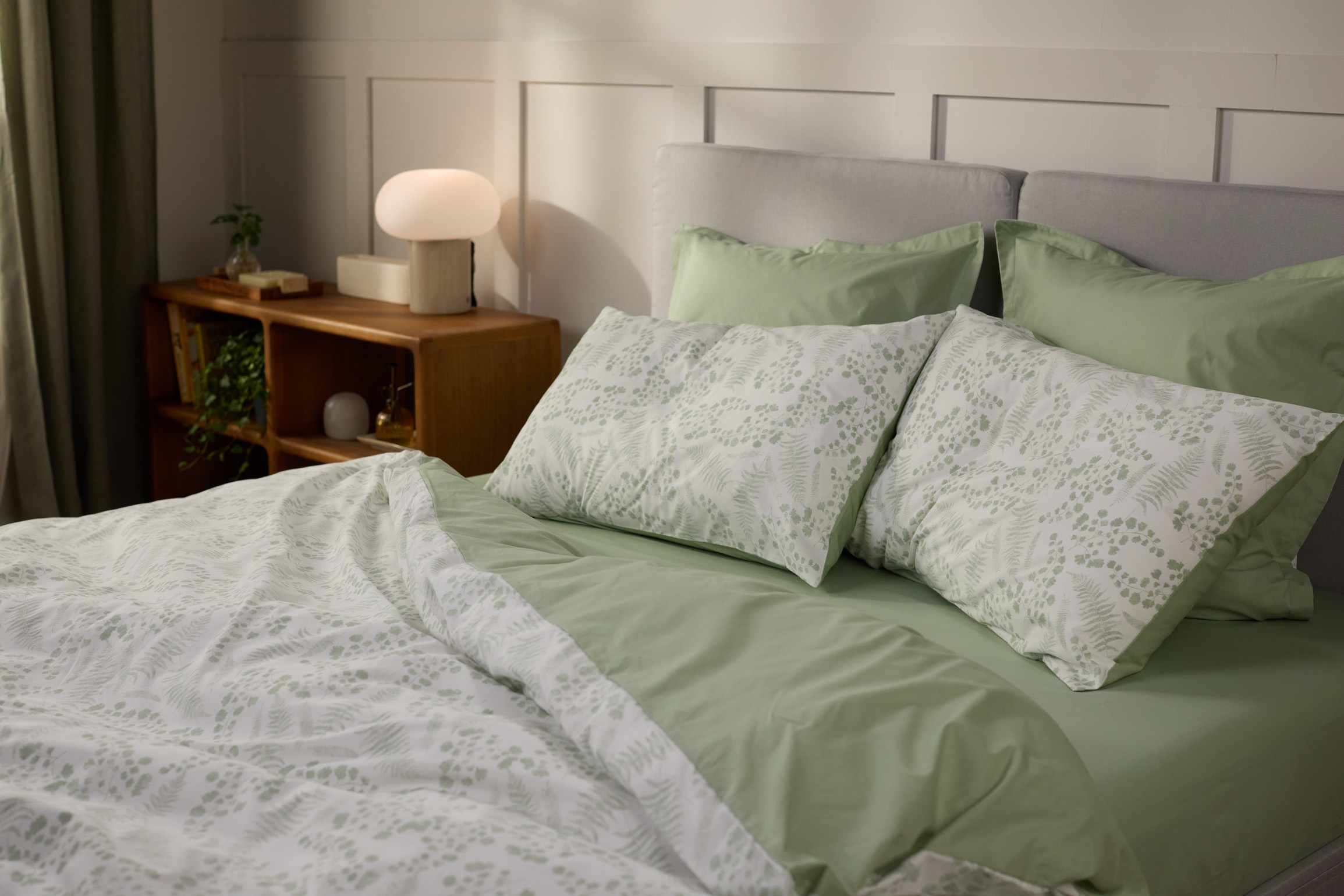 Gros plan sur des oreillers avec des taies colorées posés sur un lit.