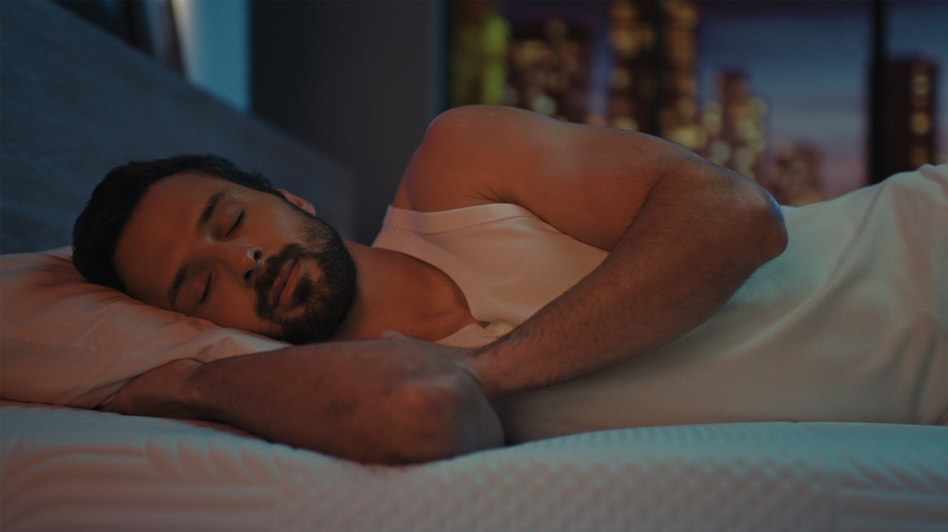 Man sleeping on Emma Performance mattress with head supported on pillow.