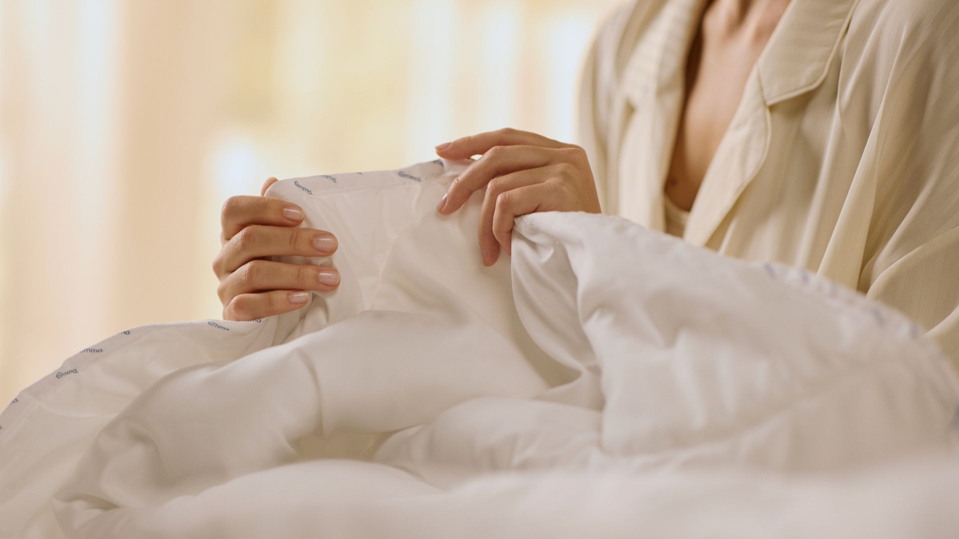 Person's hands holding a duvet.