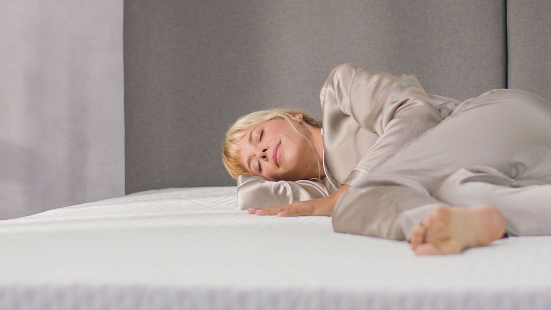 Captura la esencia del descanso perfecto con una persona acostada y relajada sobre el colchón Emma Elite con tecnología AirGrid. Ideal para quienes buscan soporte superior y una experiencia de sueño reparador.