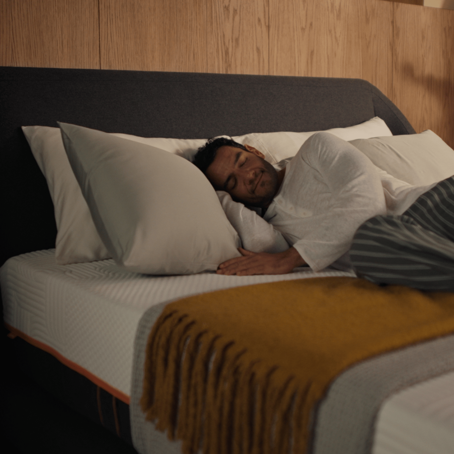 Man sleeping on Emma Performance boxspringbed, showing Deep-Calm cradling and adaptive body contouring.