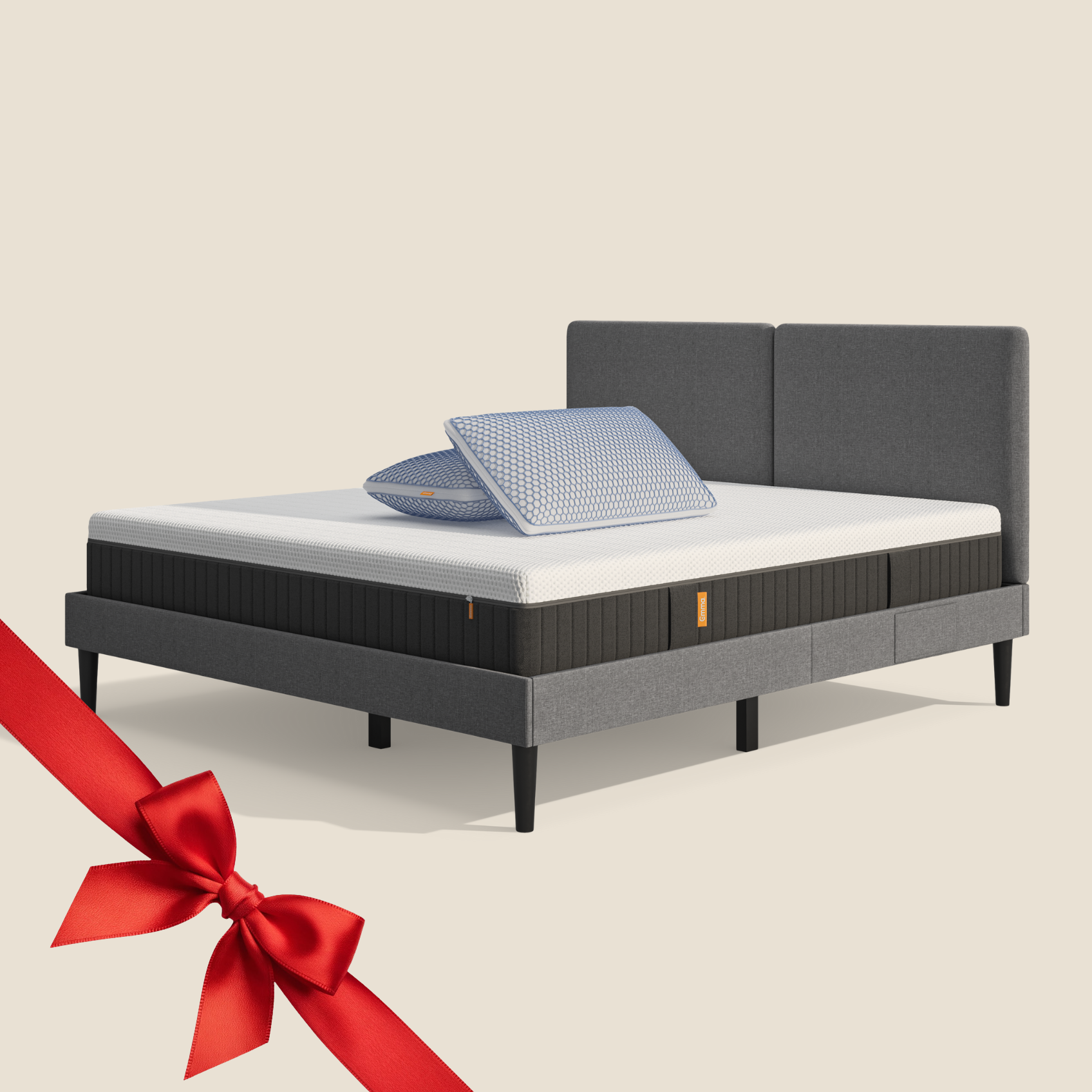 Lit moderne avec tête de lit grise et pieds noirs, recouvert de draps blancs. Deux oreillers blancs et une pile de linge plié sont posés sur le matelas. Arrière-plan beige avec une forme orange abstraite.