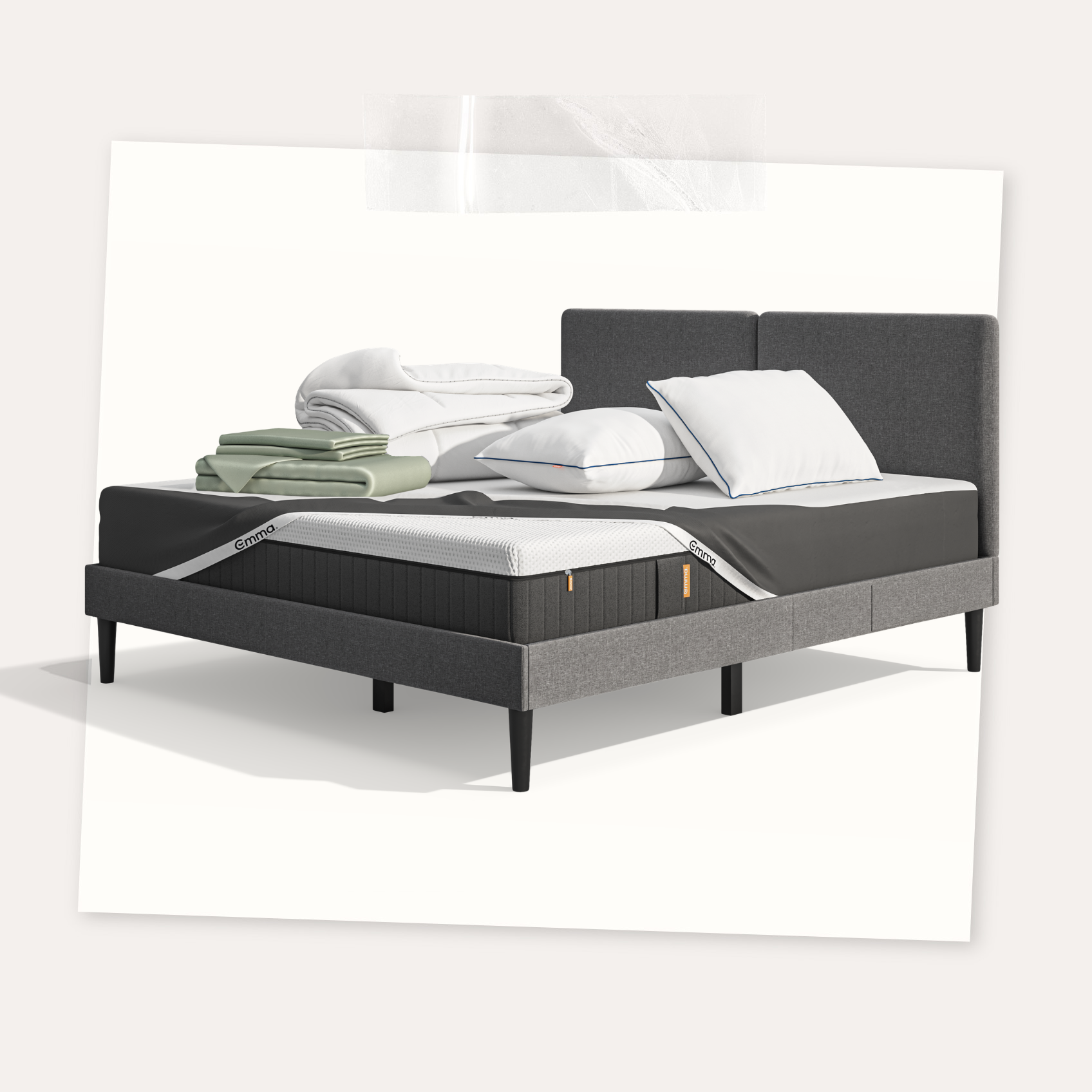 Lit moderne avec tête de lit grise et pieds noirs, recouvert de draps blancs. Deux oreillers blancs et une pile de linge plié sont posés sur le matelas. Arrière-plan beige avec une forme orange abstraite.