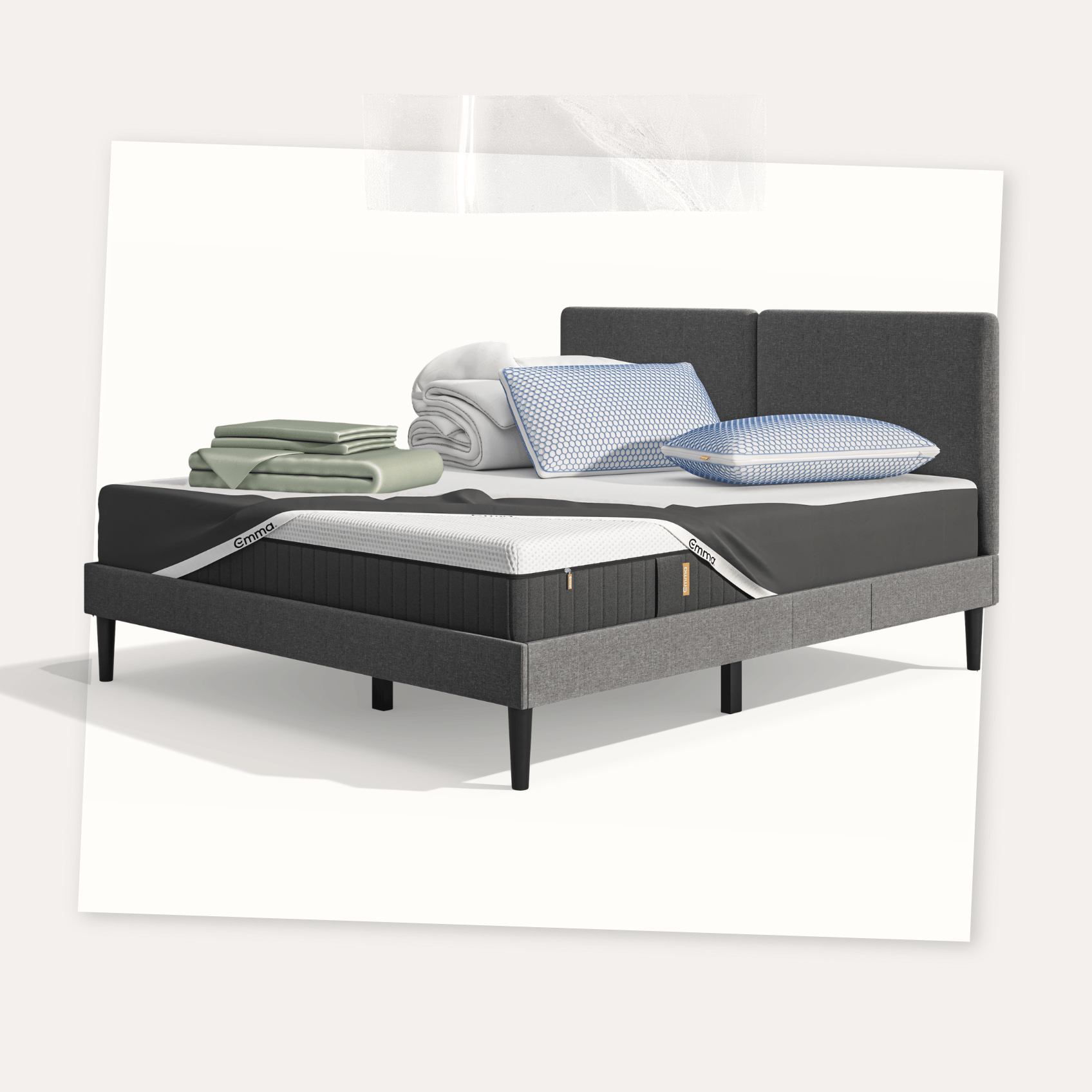 Lit moderne avec tête de lit grise et pieds noirs, recouvert de draps blancs. Deux oreillers blancs et une pile de linge plié sont posés sur le matelas. Arrière-plan beige avec une forme orange abstraite.