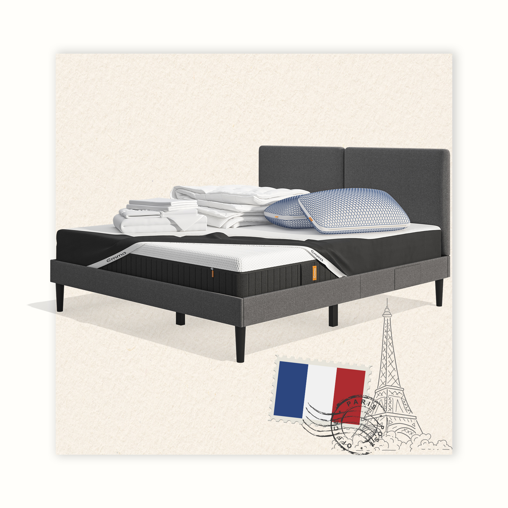 Lit moderne avec tête de lit grise et pieds noirs, recouvert de draps blancs. Deux oreillers blancs et une pile de linge plié sont posés sur le matelas. Arrière-plan beige avec une forme orange abstraite.