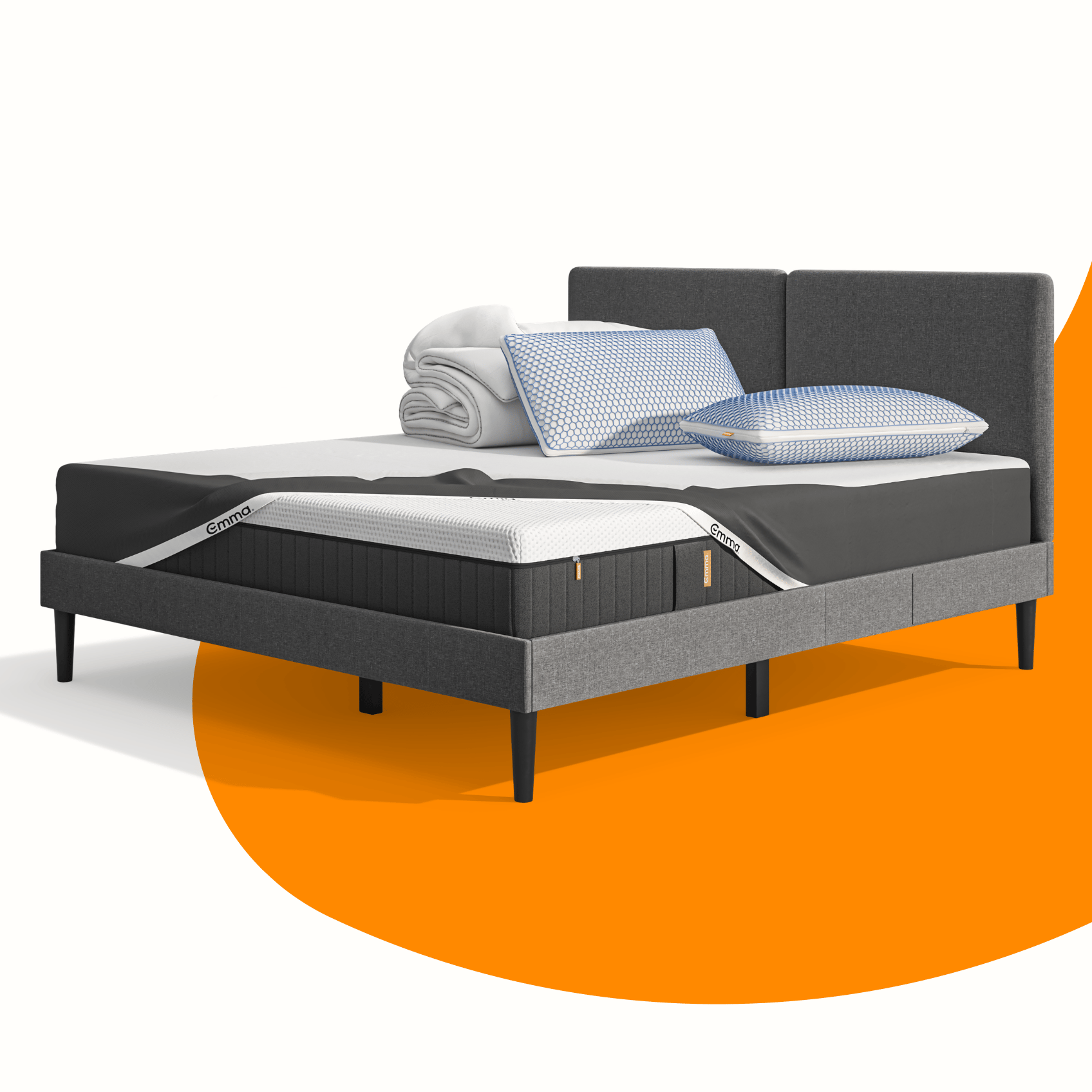 Lit moderne avec tête de lit grise et pieds noirs, recouvert de draps blancs. Deux oreillers blancs et une pile de linge plié sont posés sur le matelas. Arrière-plan beige avec une forme orange abstraite.