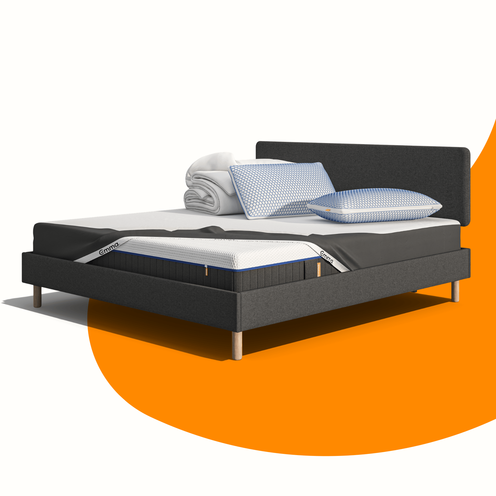 Lit moderne avec tête de lit grise et pieds noirs, recouvert de draps blancs. Deux oreillers blancs et une pile de linge plié sont posés sur le matelas. Arrière-plan beige avec une forme orange abstraite.