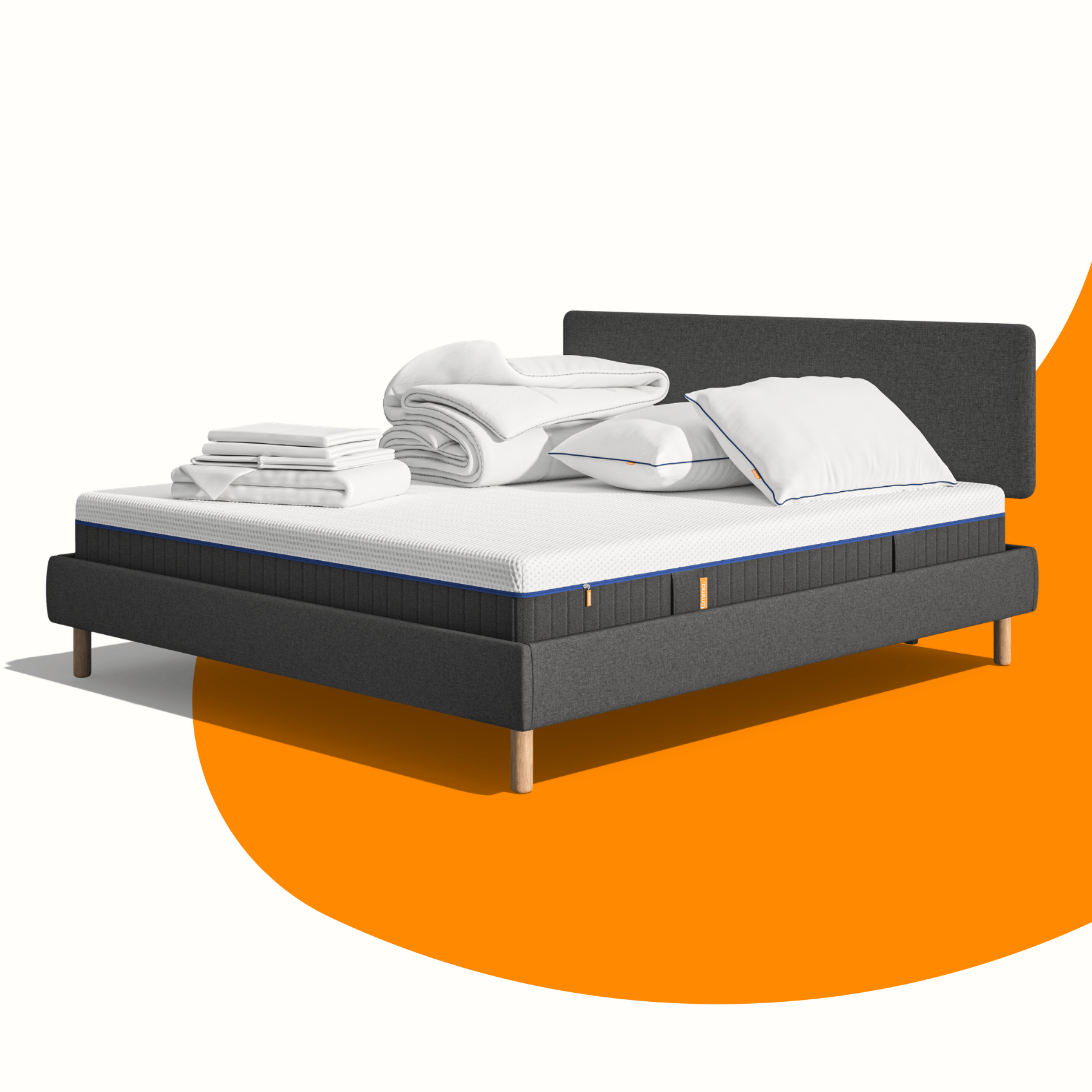 Lit moderne avec tête de lit grise et pieds noirs, recouvert de draps blancs. Deux oreillers blancs et une pile de linge plié sont posés sur le matelas. Arrière-plan beige avec une forme orange abstraite.