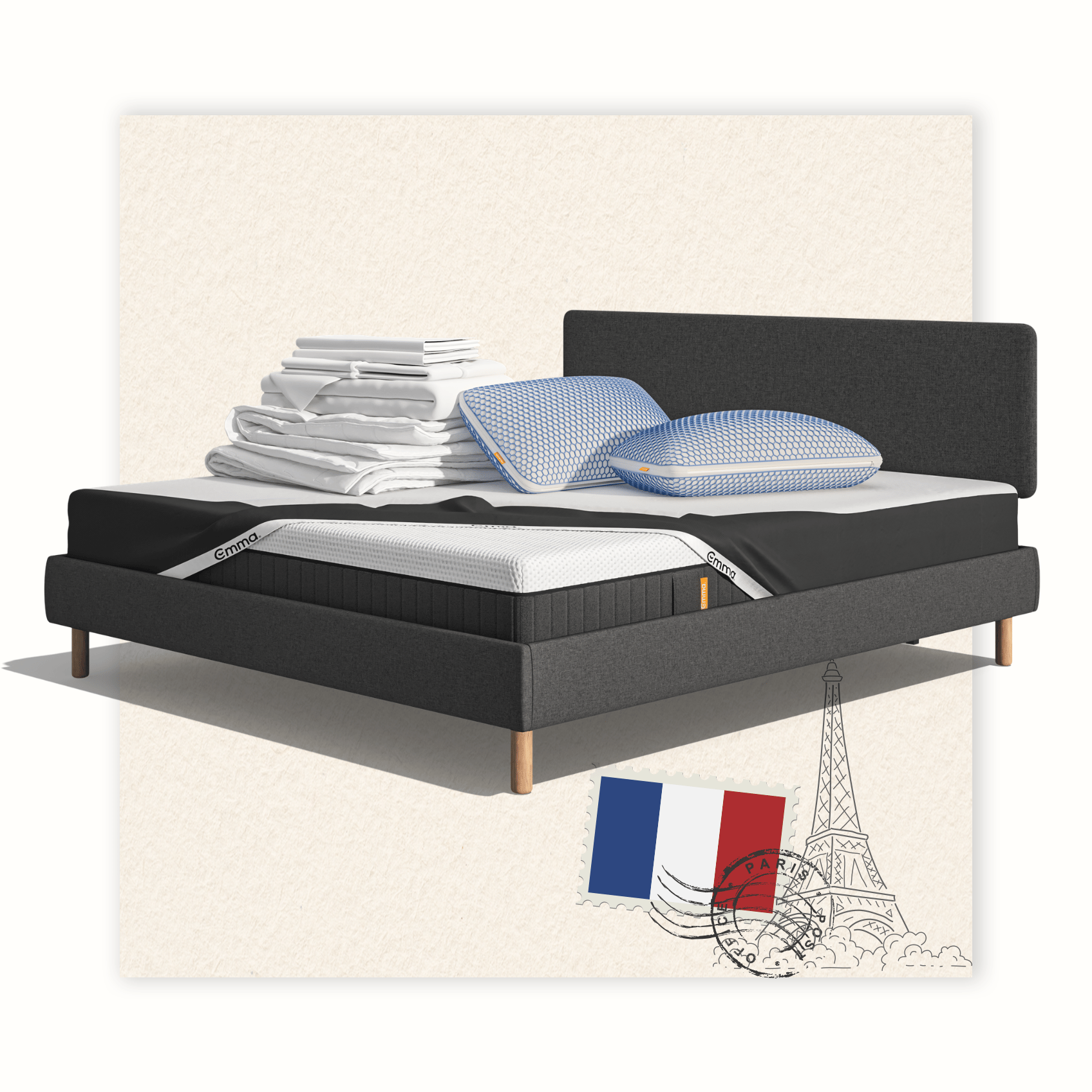 Lit moderne avec tête de lit grise et pieds noirs, recouvert de draps blancs. Deux oreillers blancs et une pile de linge plié sont posés sur le matelas. Arrière-plan beige avec une forme orange abstraite.