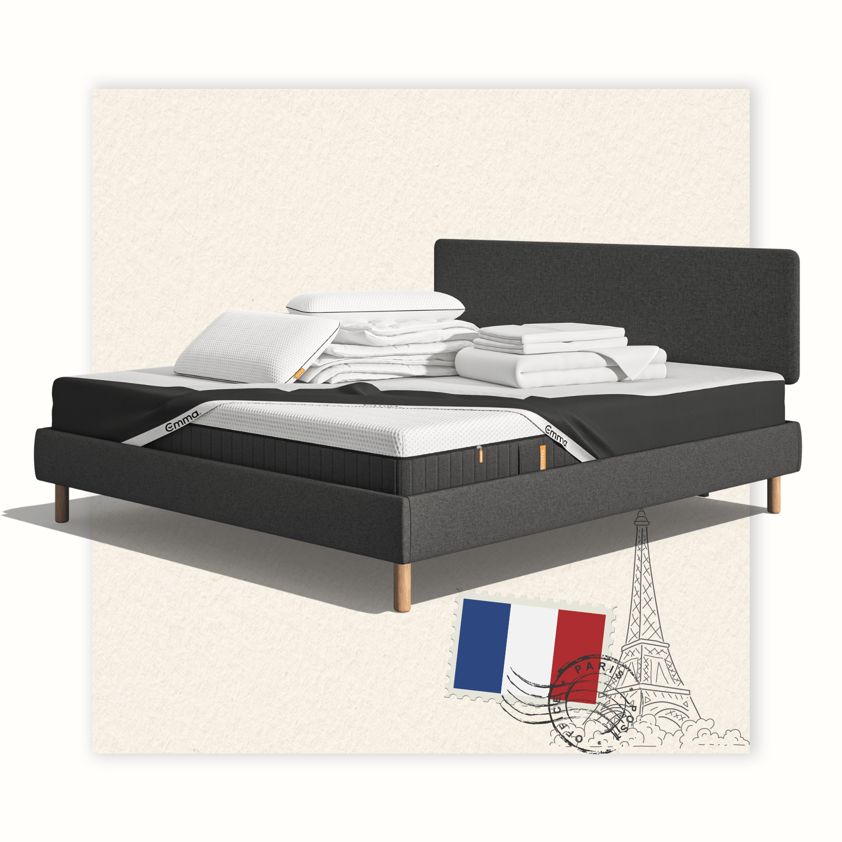 Lit moderne avec tête de lit grise et pieds noirs, recouvert de draps blancs. Deux oreillers blancs et une pile de linge plié sont posés sur le matelas. Arrière-plan beige avec une forme orange abstraite.