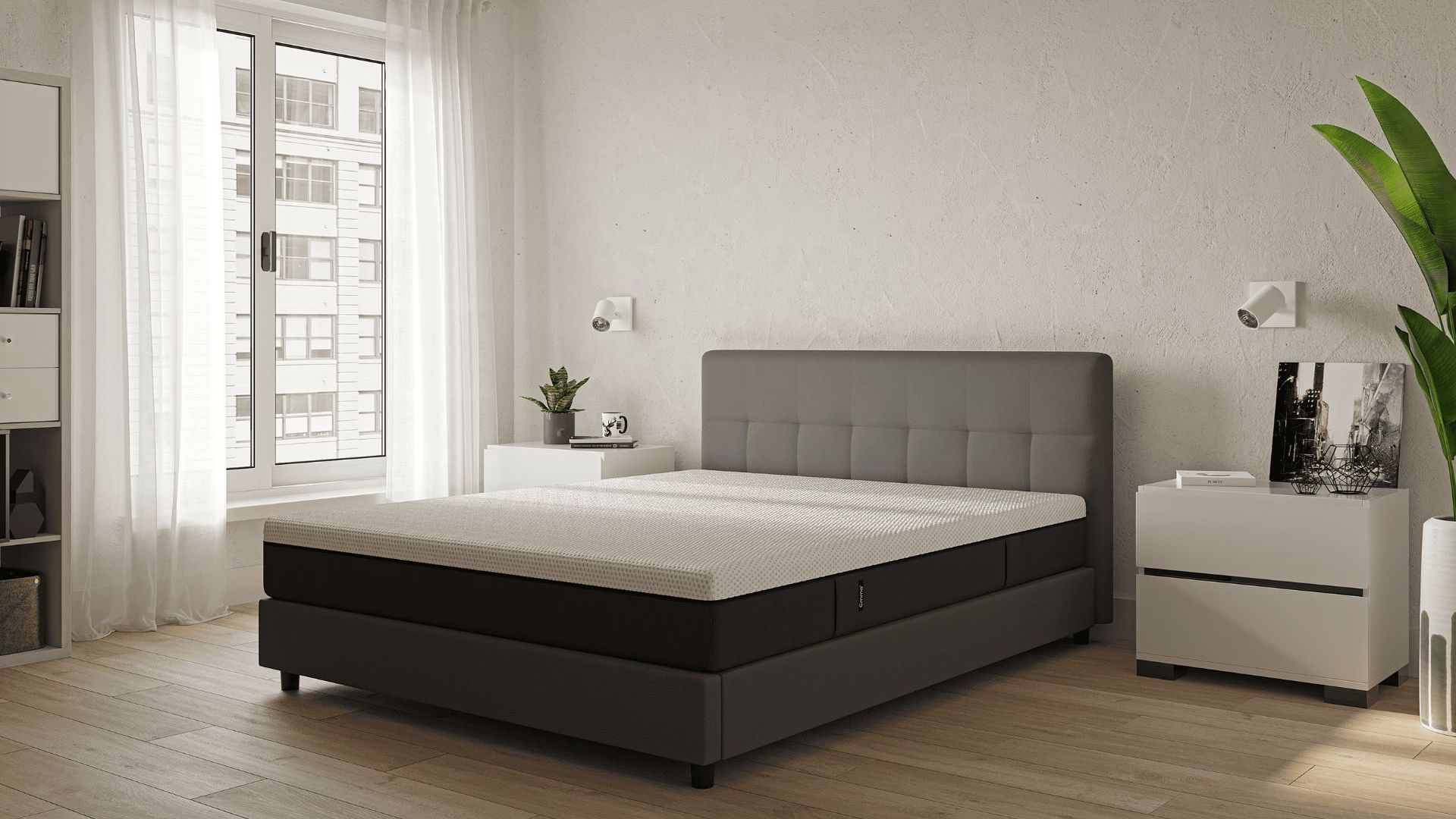 Camera moderna con letto imbottito grigio, comodini bianchi e ampie finestre con tende bianche.